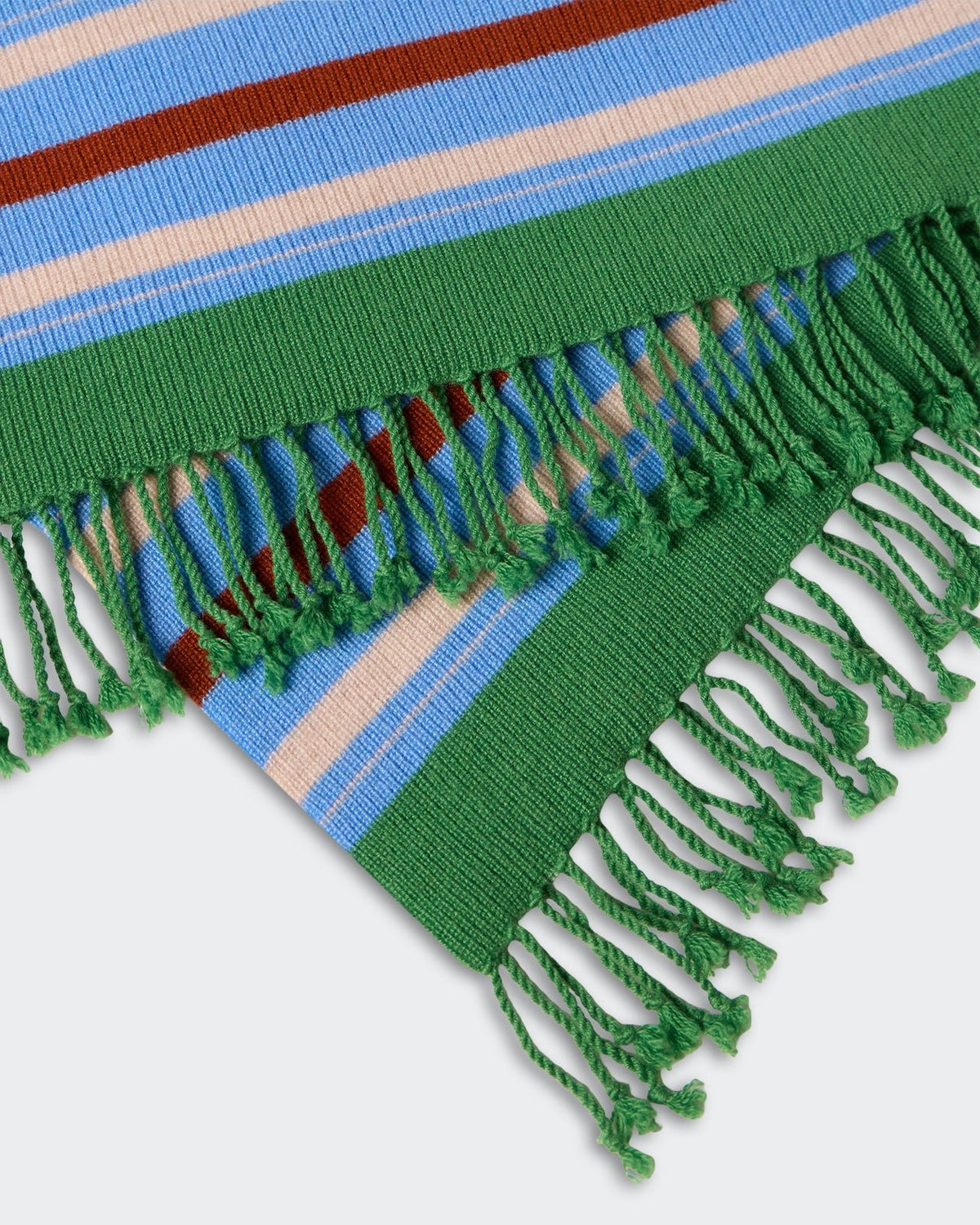 Close-up of the striped fabric with green fringed edges on the Striped Blanket - Highland Combo showing blue, beige, and brown horizontal stripes in a woven texture.