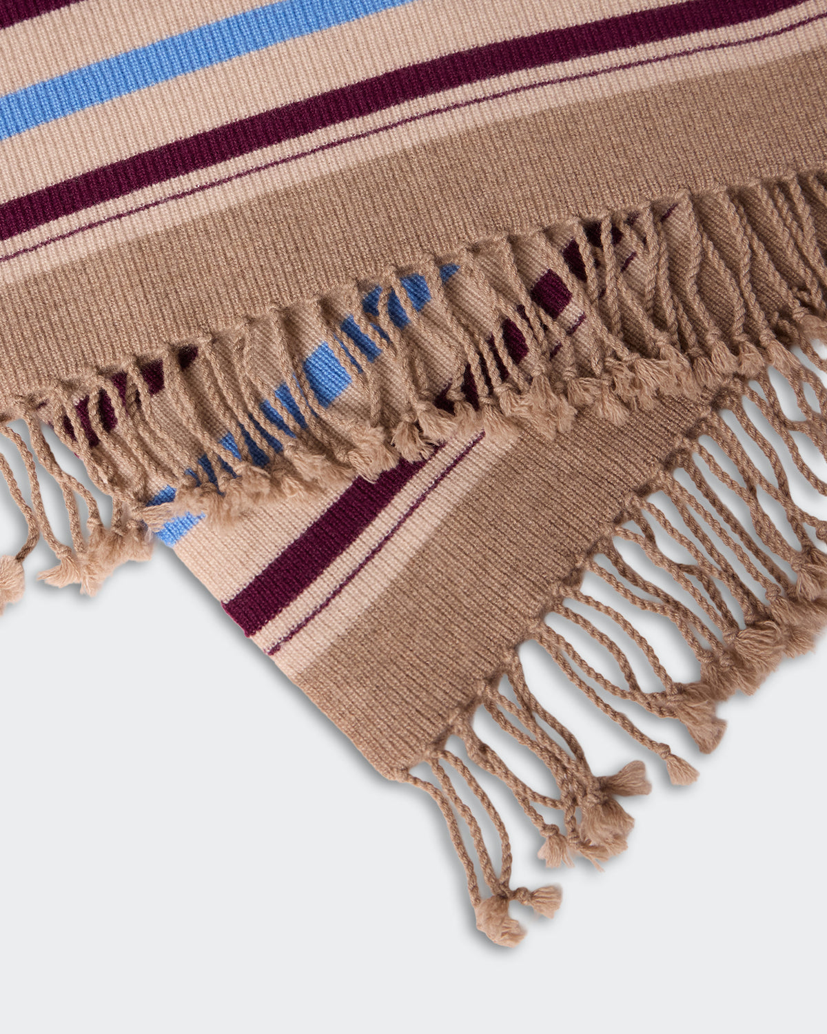 Close-up of soft woven fabric edges with tasseled fringes in beige, blue, and burgundy stripes, showcasing the texture and design of the Striped Blanket - Sandstone Combo.