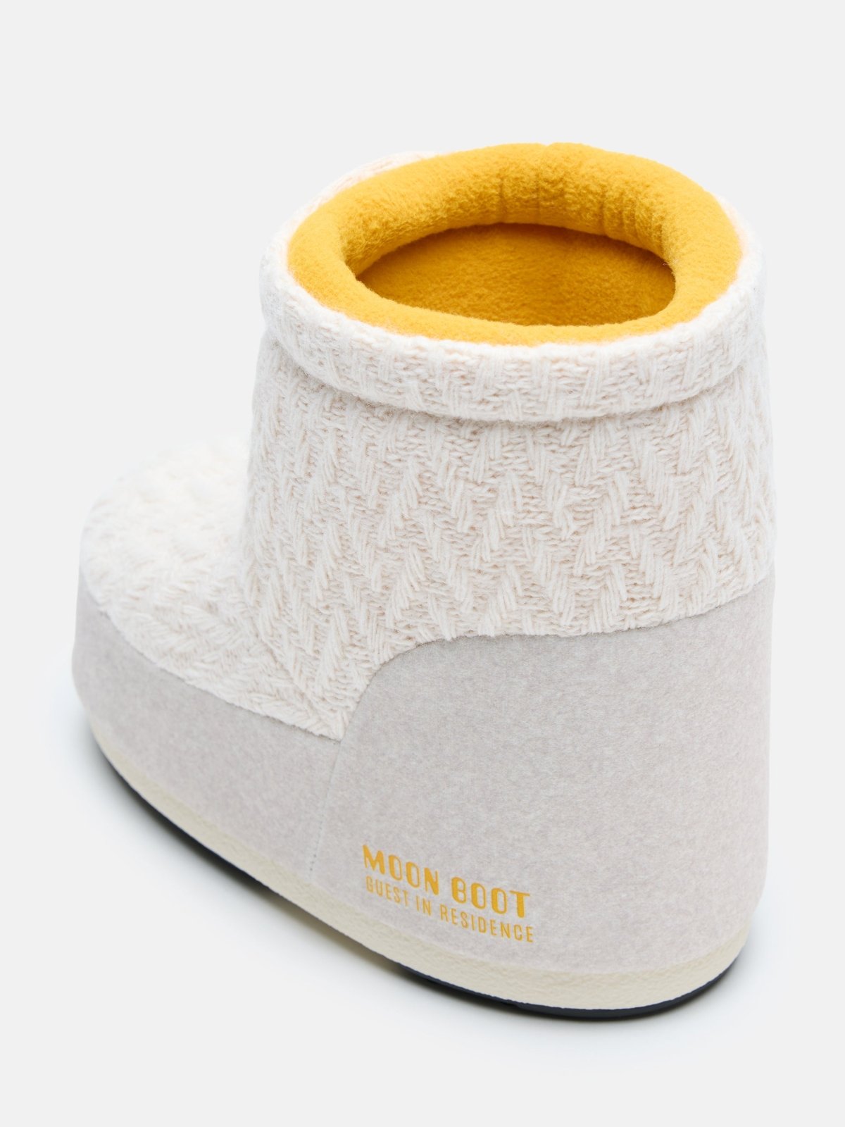White knit low boot with yellow interior lining and soft cushioned sole viewed from the back angle
