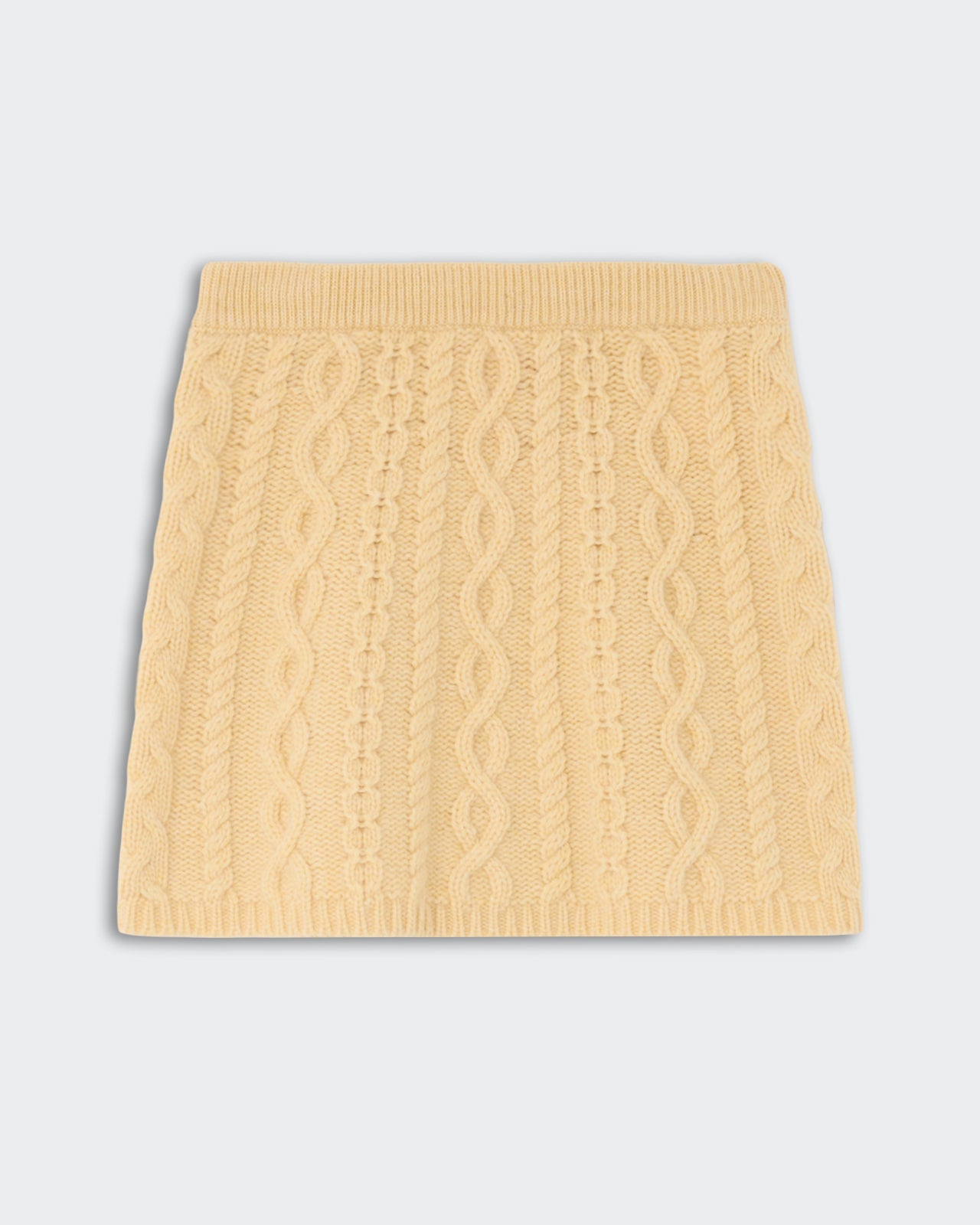 Cable Mini Skirt - Butter featuring a soft, textured cable knit pattern in a warm yellow shade with a ribbed waistband and hem.