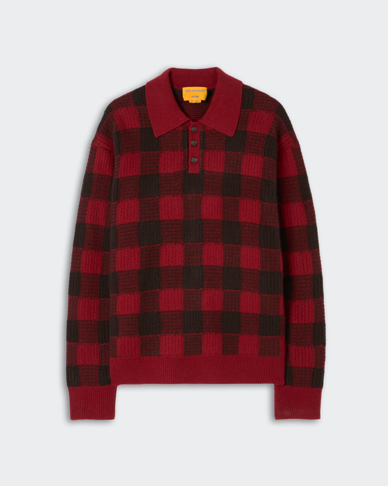 Red and dark brown checkered knit sweater with a polo collar and four dark buttons on the front placket, laid flat on a light background.