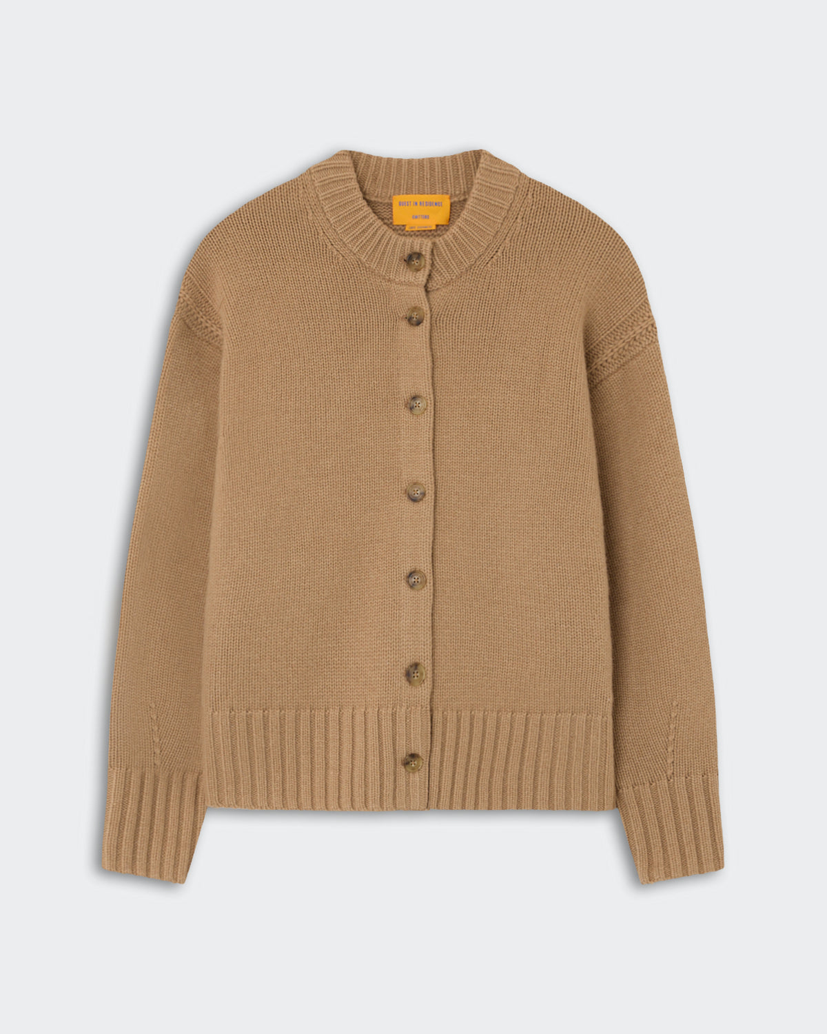 Tan knitted cardigan with a ribbed collar, cuffs, and hem, featuring a front button closure with six buttons on a light gray background.