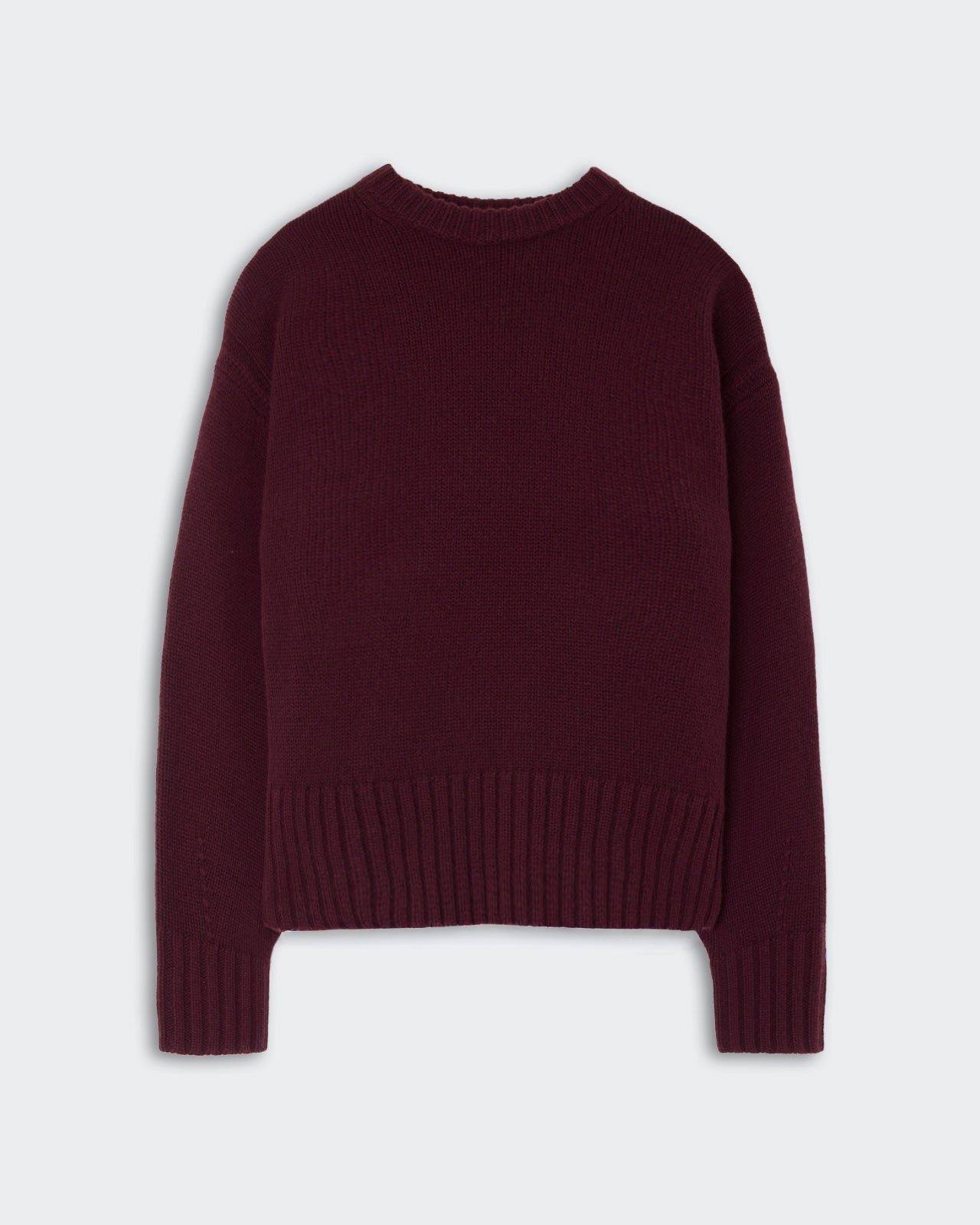 Dark burgundy knitted sweater with long sleeves and ribbed cuffs and hem laid flat on a light background.
