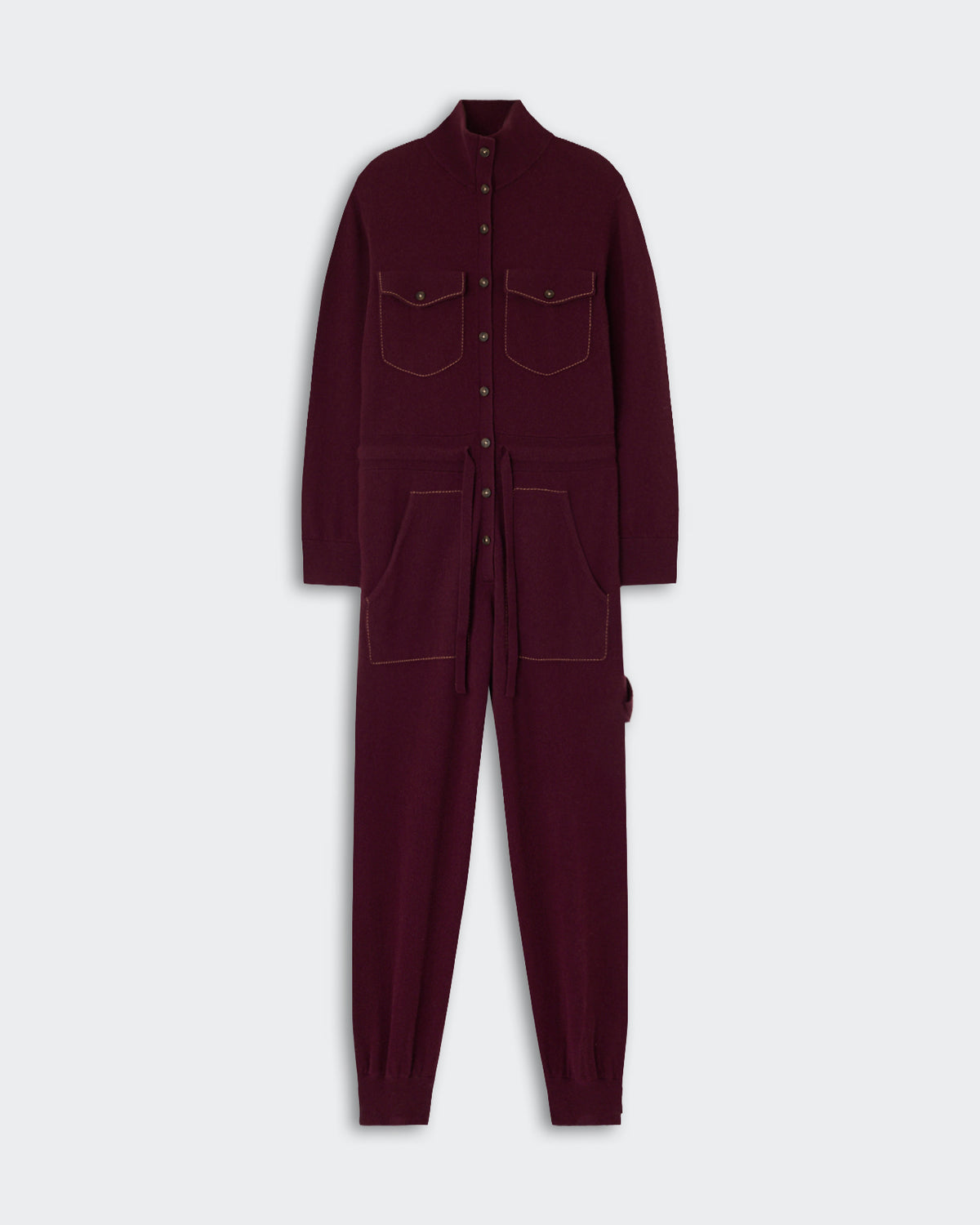 Full-length burgundy knit jumpsuit with long sleeves, button-up front, high collar, chest patch pockets, front large pockets, and a waist tie belt against a light background.