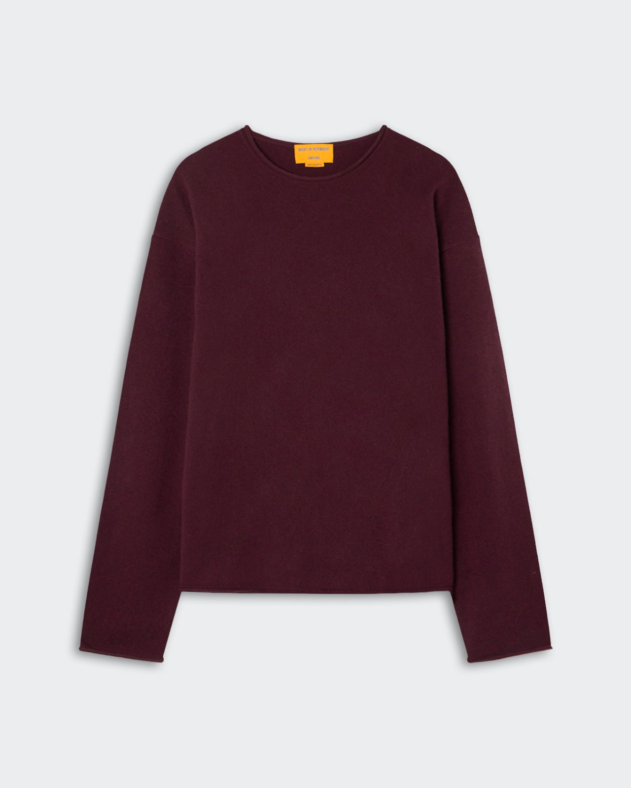 Long-sleeve crew neck sweater in dark burgundy color laid flat on a light gray background with a small yellow label inside the neckline.