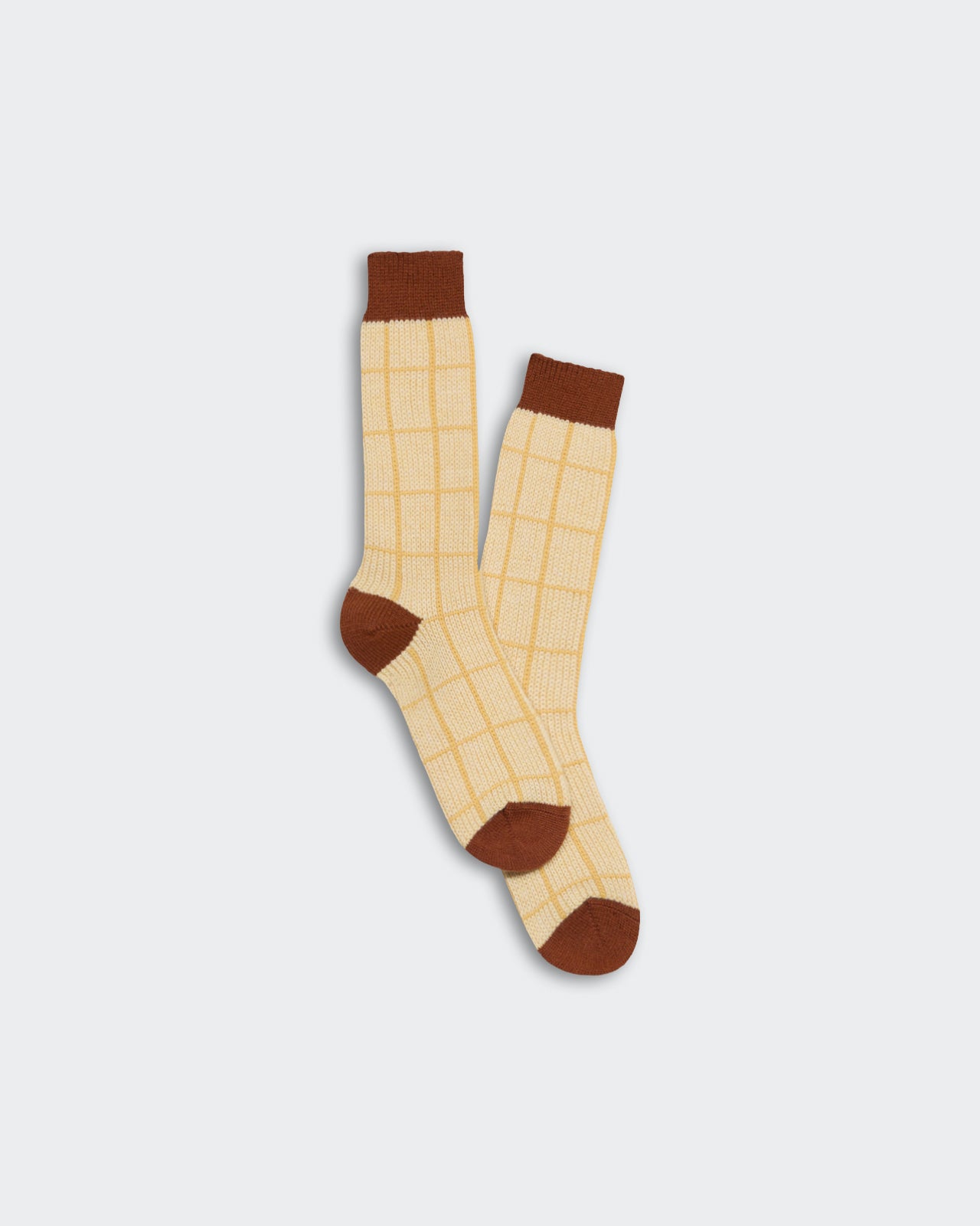 A pair of light yellow socks with a brown checker pattern, featuring solid brown cuffs, heels, and toes labeled The Checker Soft Sock - Butter Combo.