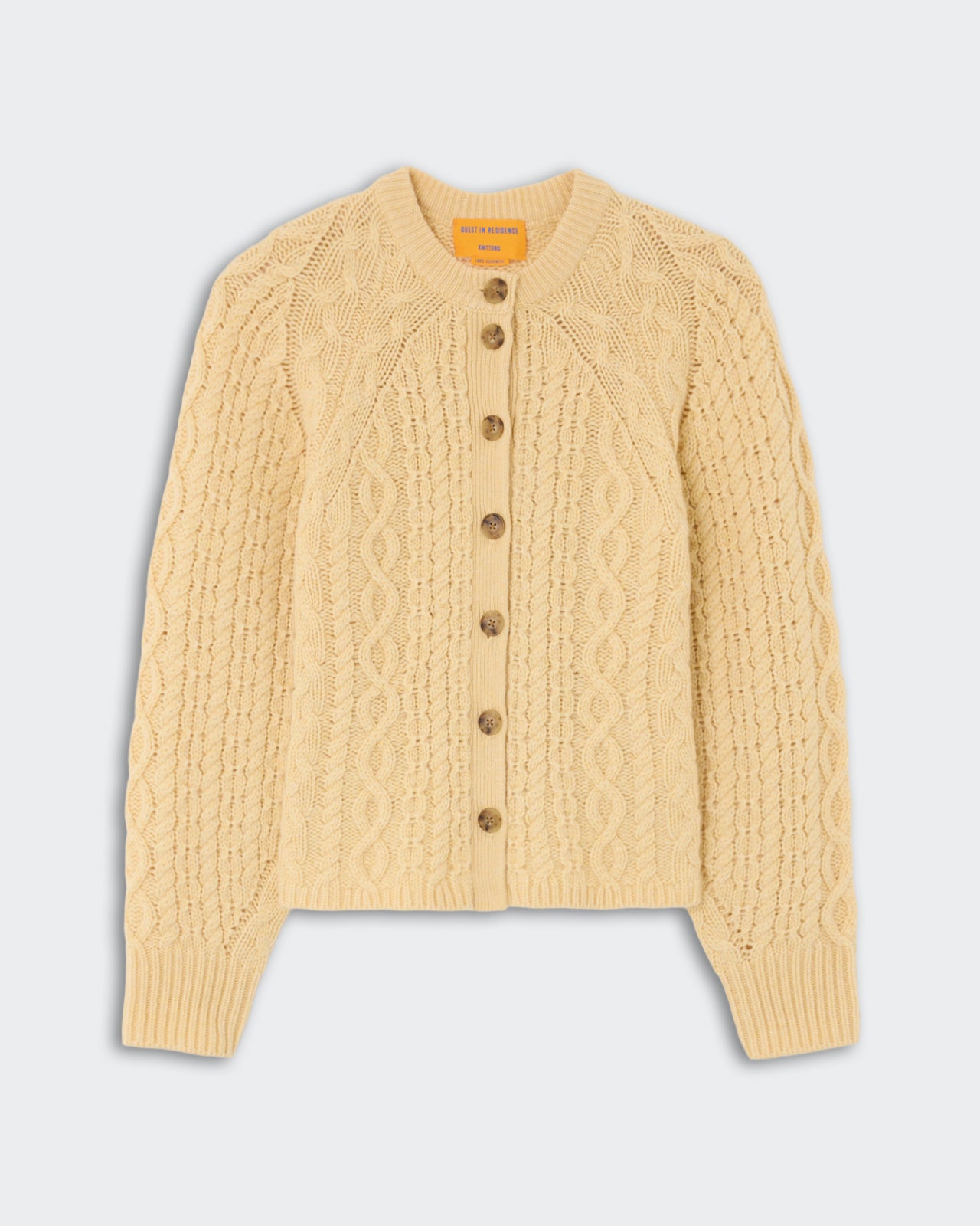 Cable Sculpted Cardigan - Butter featuring intricate cable knit pattern, long sleeves, button-up front, and ribbed cuffs in a soft butter yellow shade.