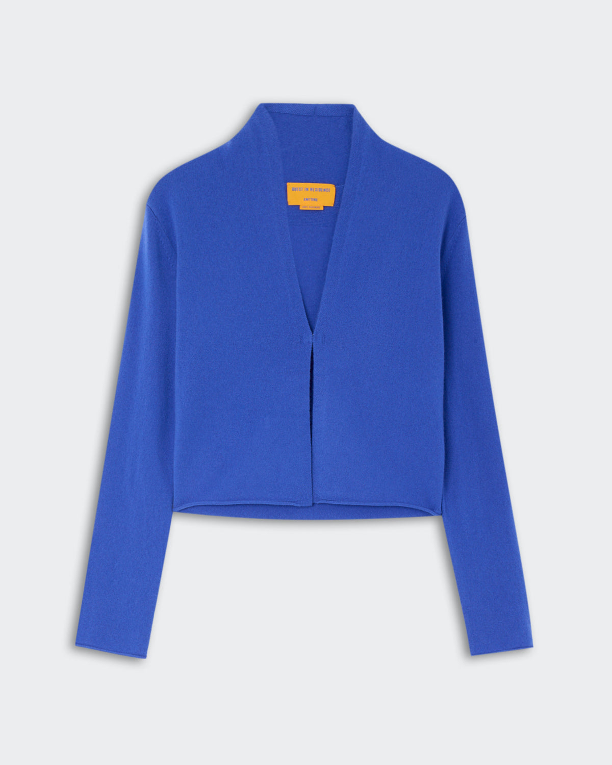 Cobalt blue long-sleeve cardigan with a deep V-neck and a cropped hem, laid flat on a light gray background.