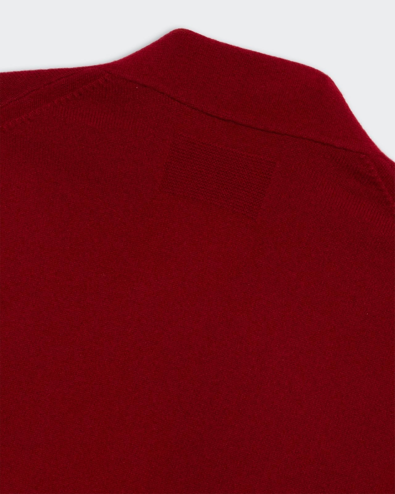 Close-up of red fabric texture on Stealth Cardigan - Ruby showing collar and stitching details.