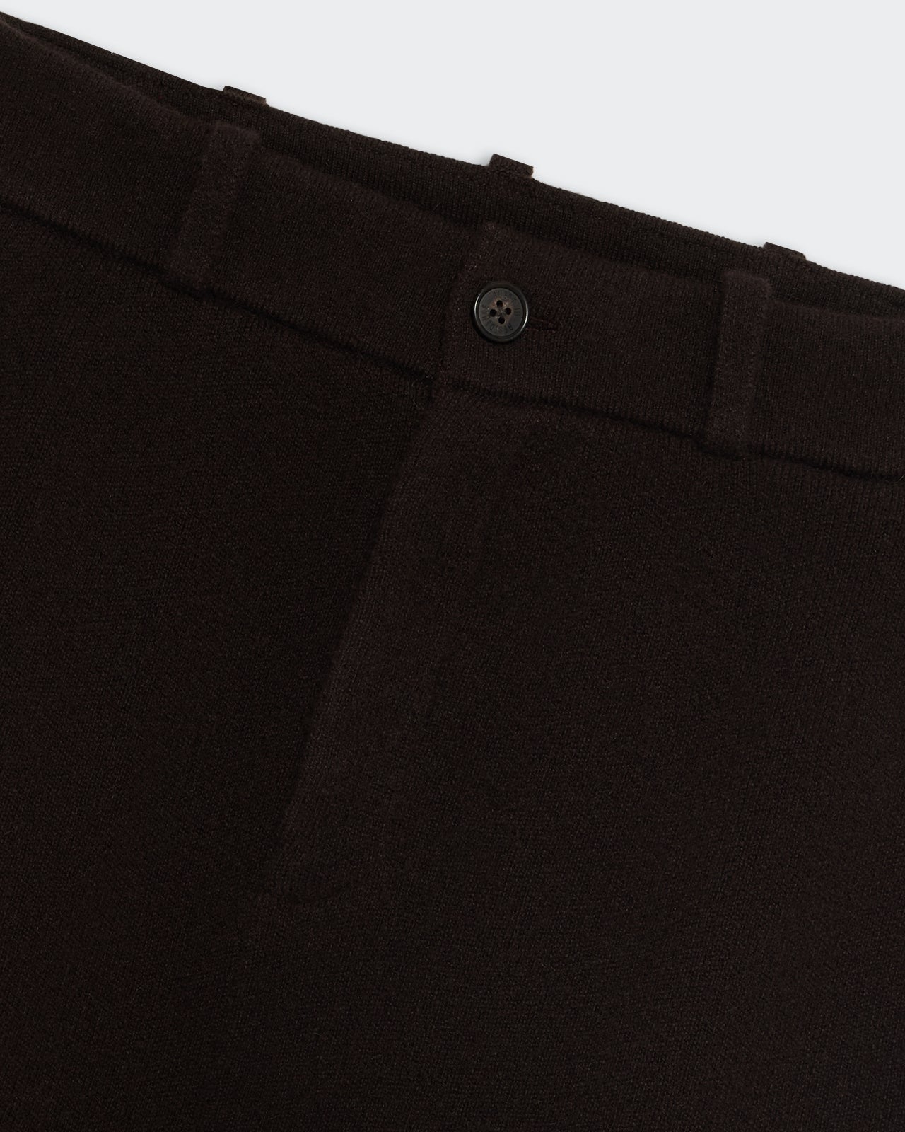 Tailored Skirt - Burnt Cocoa close-up showing button and waistband details on dark brown fabric.