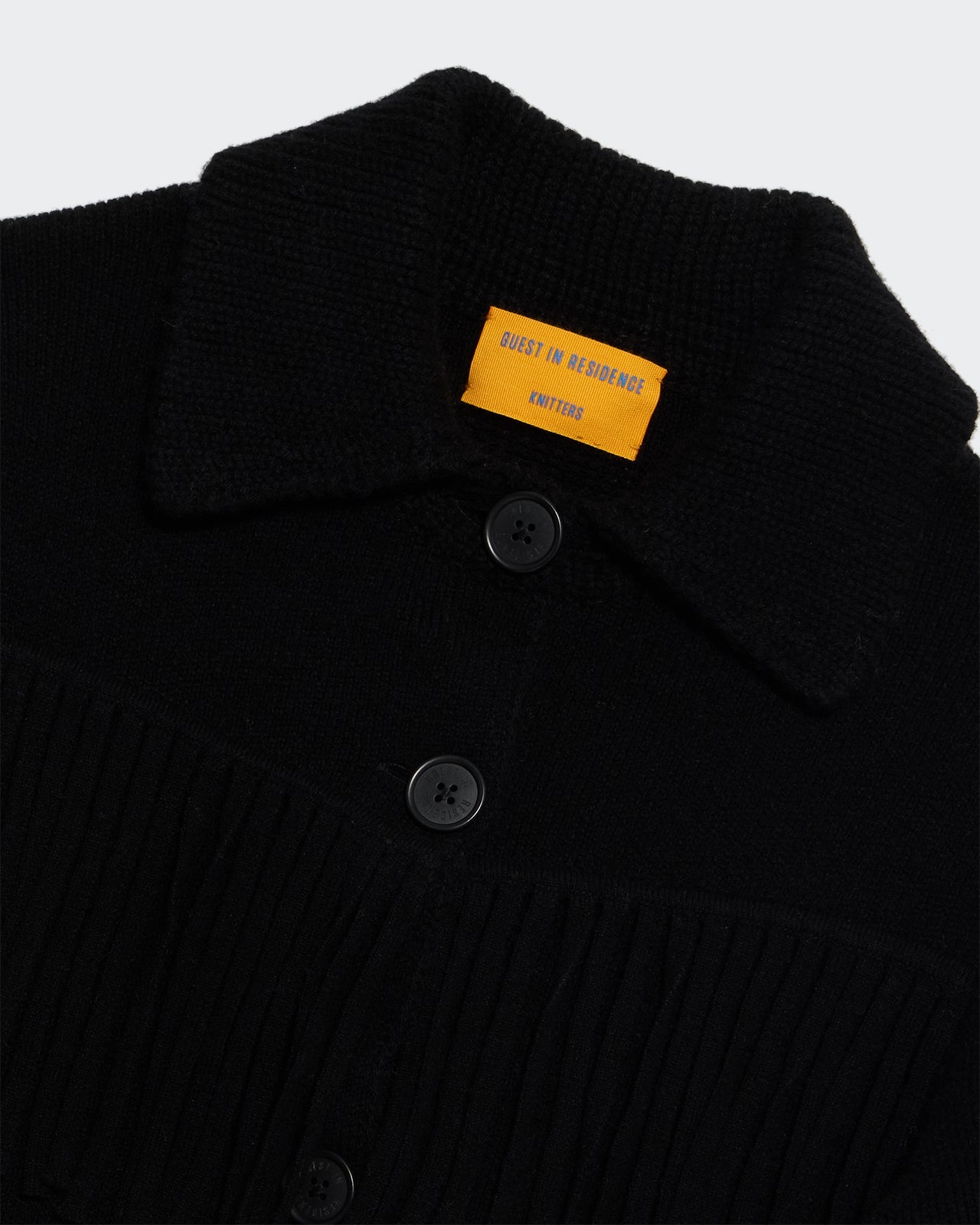 Close-up of Western Fringe Jacket - Black showing black buttons, collar, and textured knit fabric with fringe detailing.