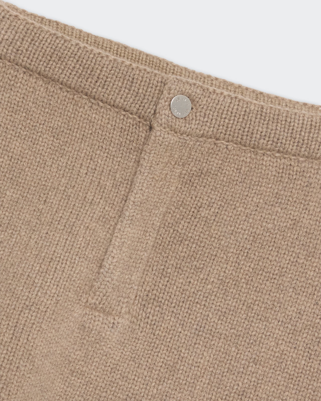 Close-up of the textured fabric and button detail on the "Jean" Mini Skirt - Taupe in a soft beige shade.