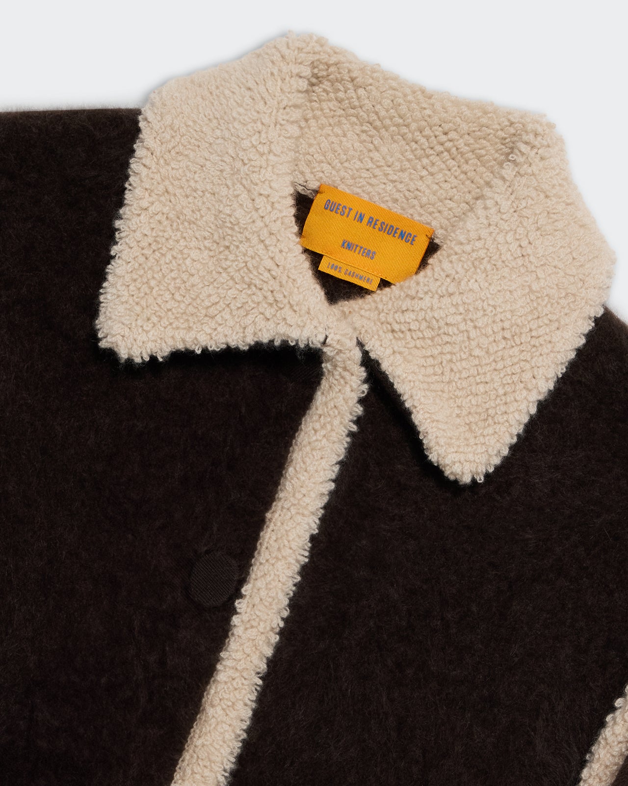Close-up of Grizzly Jacket - Burnt Cocoa/Oatmeal showing textured cream collar and dark brown body detail.