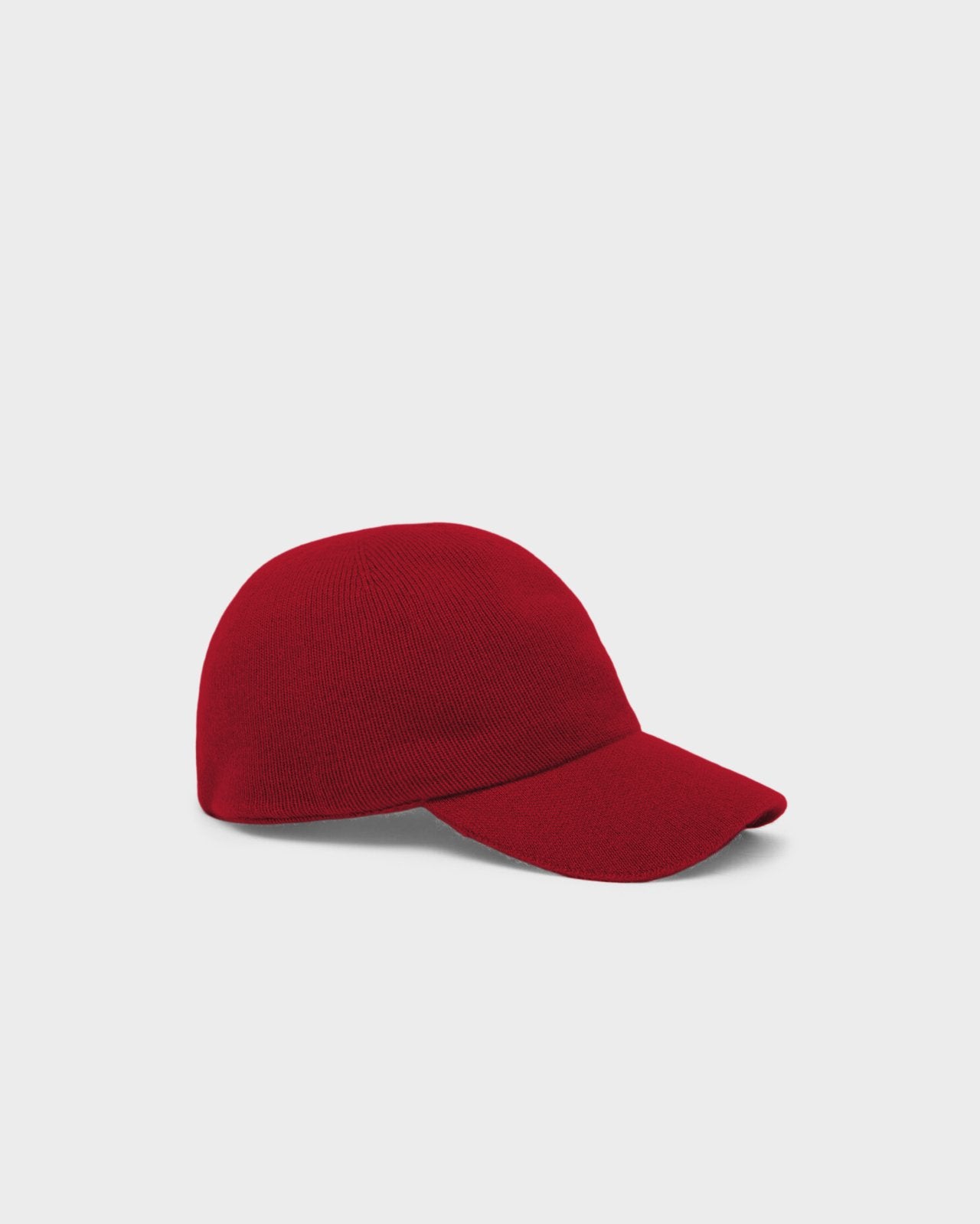 The Baseball Cap - Carmine/Burnt Cocoa in a rich carmine red knit fabric with a classic curved brim, displayed on a neutral gray background.
