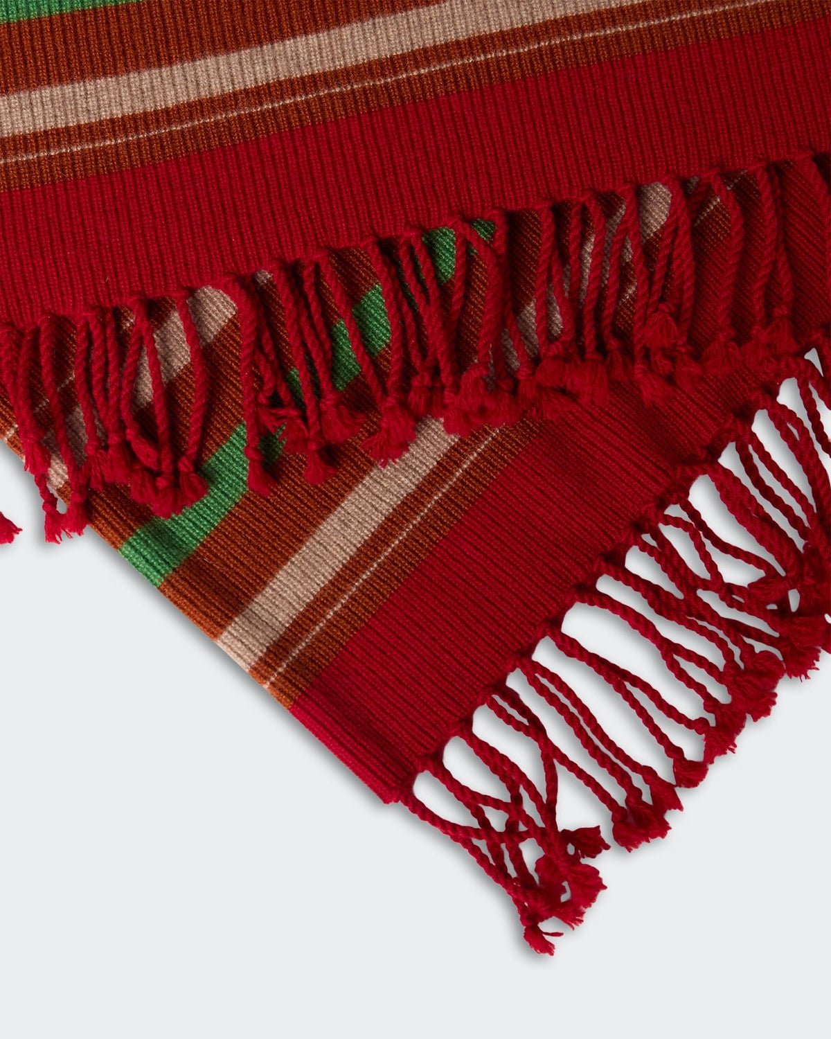 Close-up of fringed edges on a Striped Blanket - Carmine Combo featuring red, green, brown, and beige stripes in a textured woven fabric.