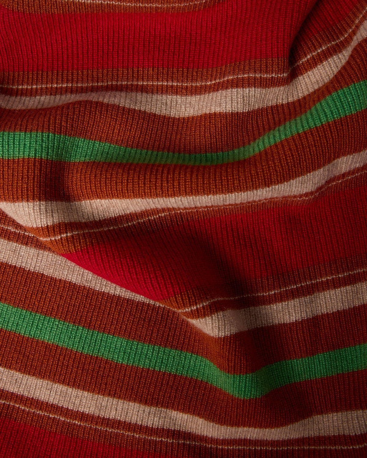 Close-up view of the textured fabric featuring bold horizontal stripes in red, green, beige, and brown colors of the Striped Blanket - Carmine Combo.