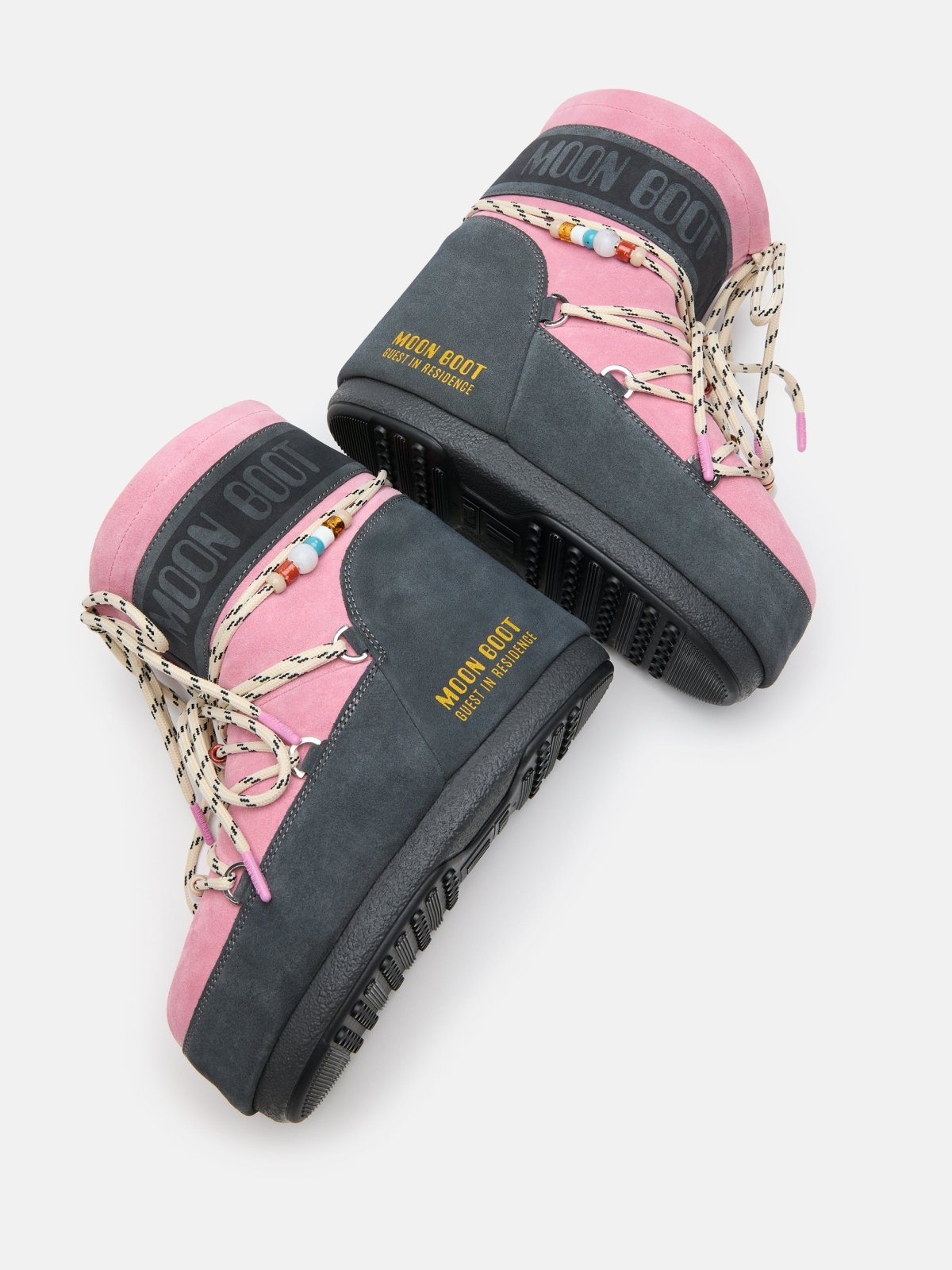 Pair of gender-neutral Moon Boot Icon Low Grey and Rose suede boots with beaded laces and metal eyelets on white background