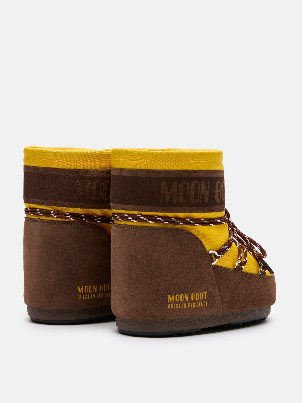 Pair of brown and yellow MB X GIR ICON LOW NYLON Moon Boot winter footwear with logo and lace-up design shown from the back.