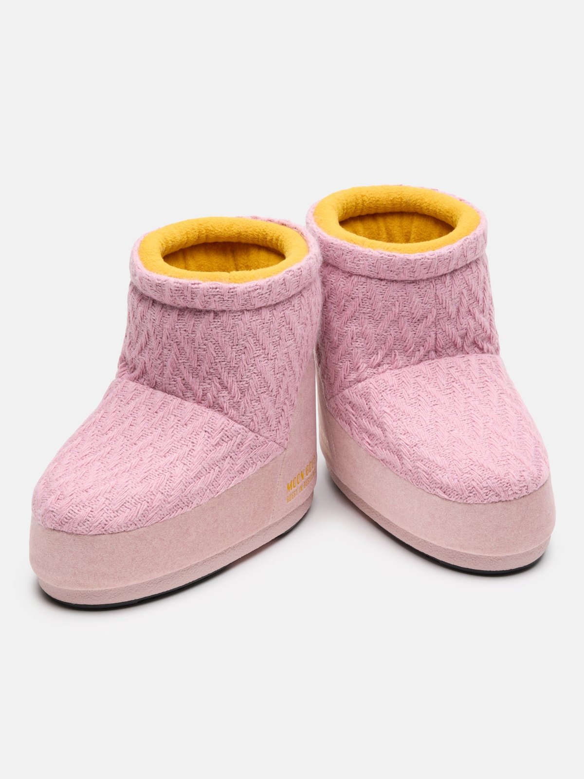 Pair of pink knit high-top slippers with yellow interior lining and soft sole on white background