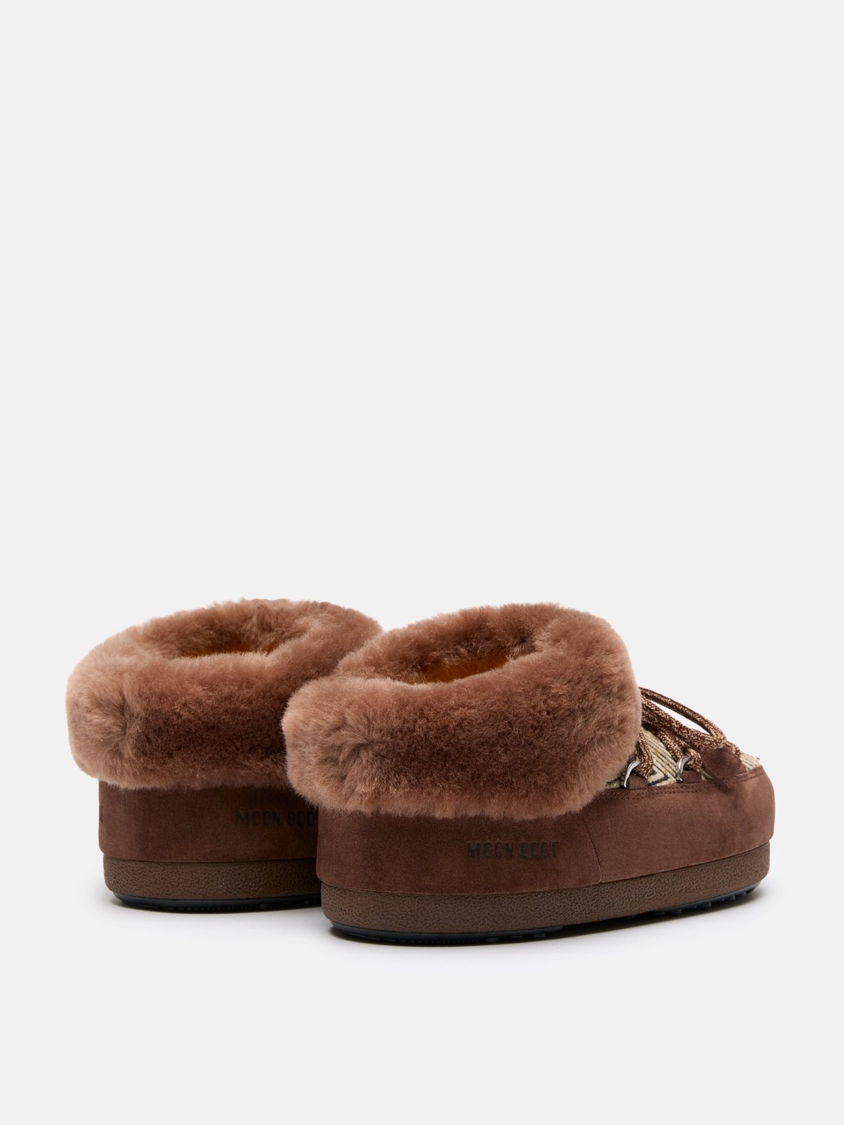 Pair of brown MB X GIR EVX Chalet Mule Fur slippers with thick plush fur collar and suede exterior viewed from the back