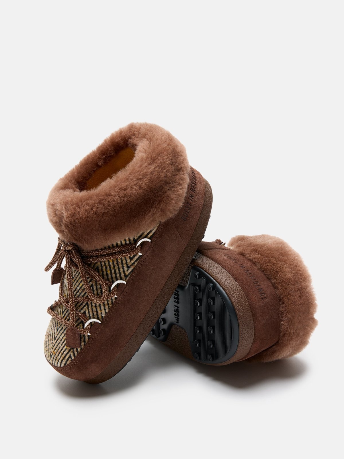 Brown fur-lined chalet mule slippers with patterned fabric and rubber sole for indoor comfort.