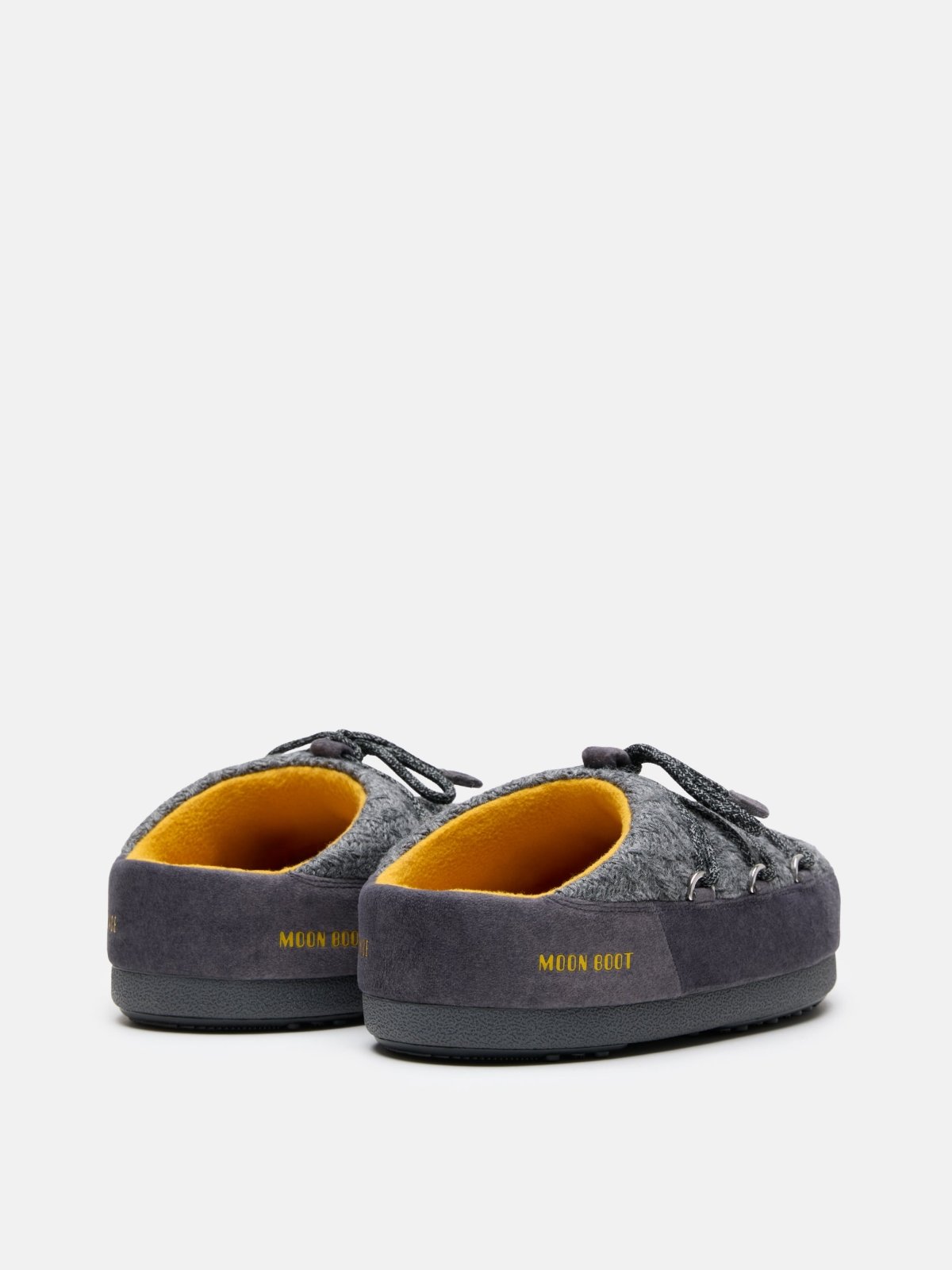 Pair of gray MB X GIR EVX Mule Knit slippers with yellow interior and lace detailing on a white background