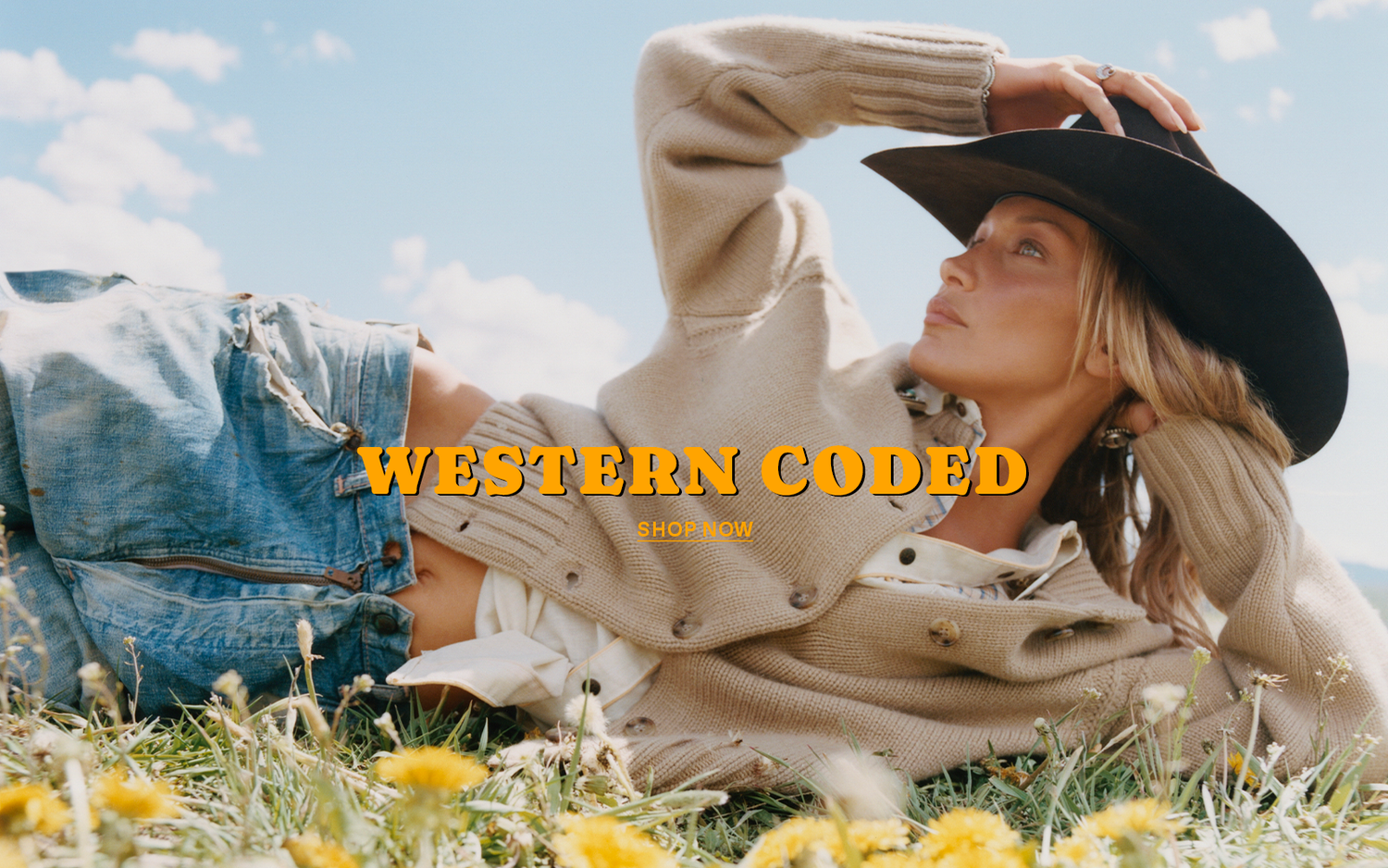 Woman in a beige knit sweater and black cowboy hat reclining in a flower filled meadow under a blue sky with Western Coded Shop Now text overlay