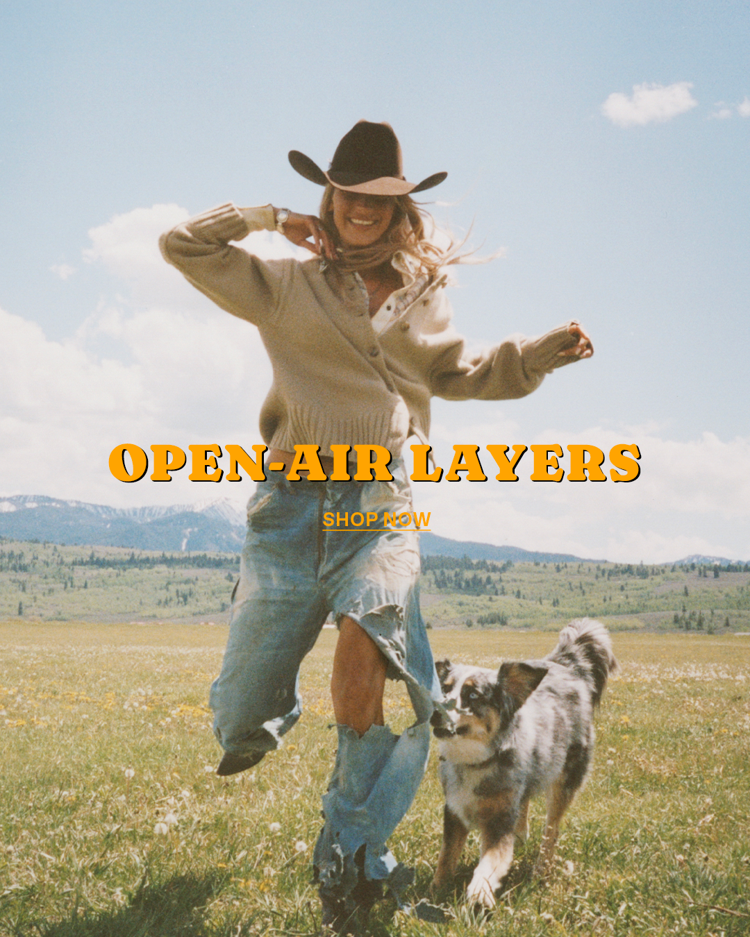 Smiling woman in a cowboy hat and cardigan dances beside a dog in a flower-filled mountain meadow beneath a blue sky, overlaid with Open-Air Layers and Shop Now text