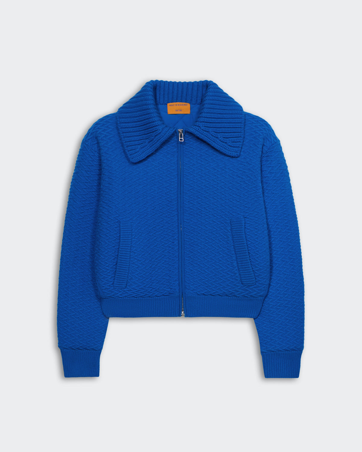Blue heavyweight textured bomber jacket with two-way zipper, chunky rib polo collar, and insulated quilted recycled polyester lining.