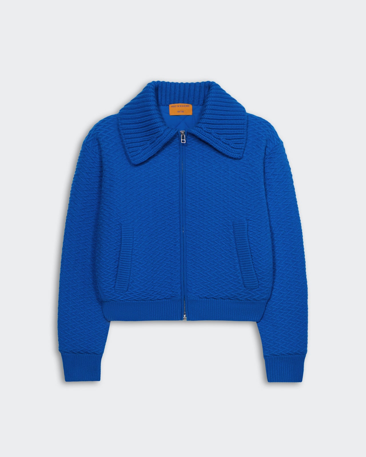 Blue heavyweight textured bomber jacket with two-way zipper, chunky rib polo collar, and insulated quilted recycled polyester lining.