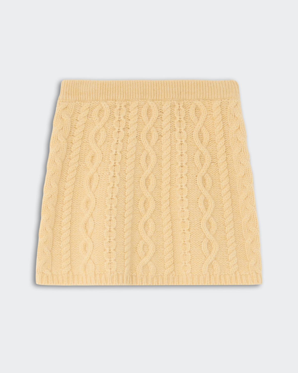 Cable Mini Skirt - Butter featuring a soft, textured cable knit pattern in a warm yellow shade with a ribbed waistband and hem.