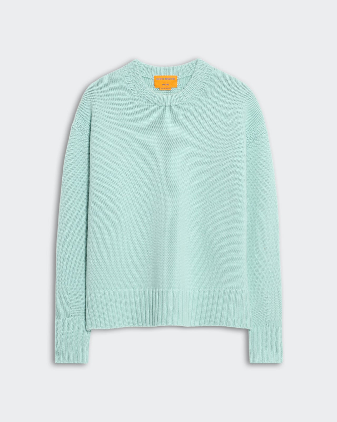 Light blue oversized women's crew neck sweater with ribbed trim on neck, cuffs, and hem, side slit detail visible