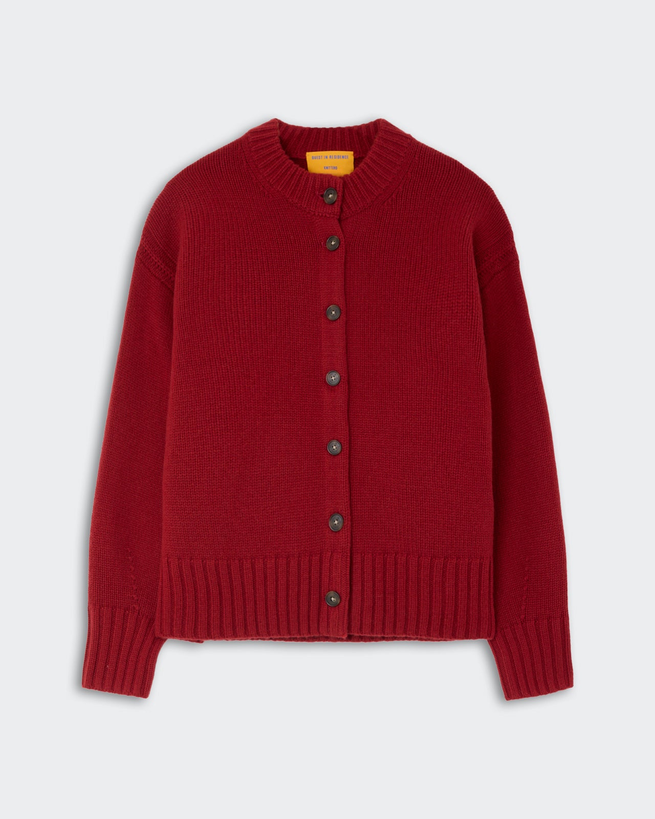 Red knit cardigan with long sleeves, ribbed cuffs and hem, button-down front, and a round neckline against a plain light background.