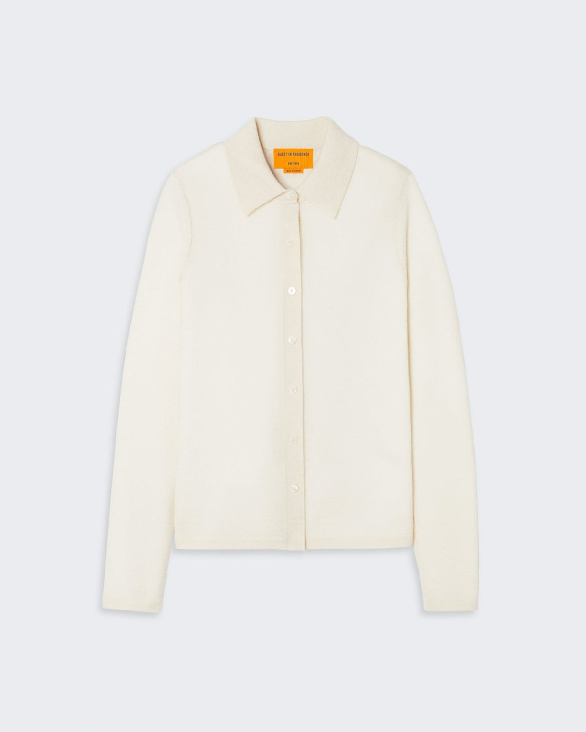 Cream-colored cashmere shirt with button-down collar and front patch pocket, featuring the brand's signature logo.