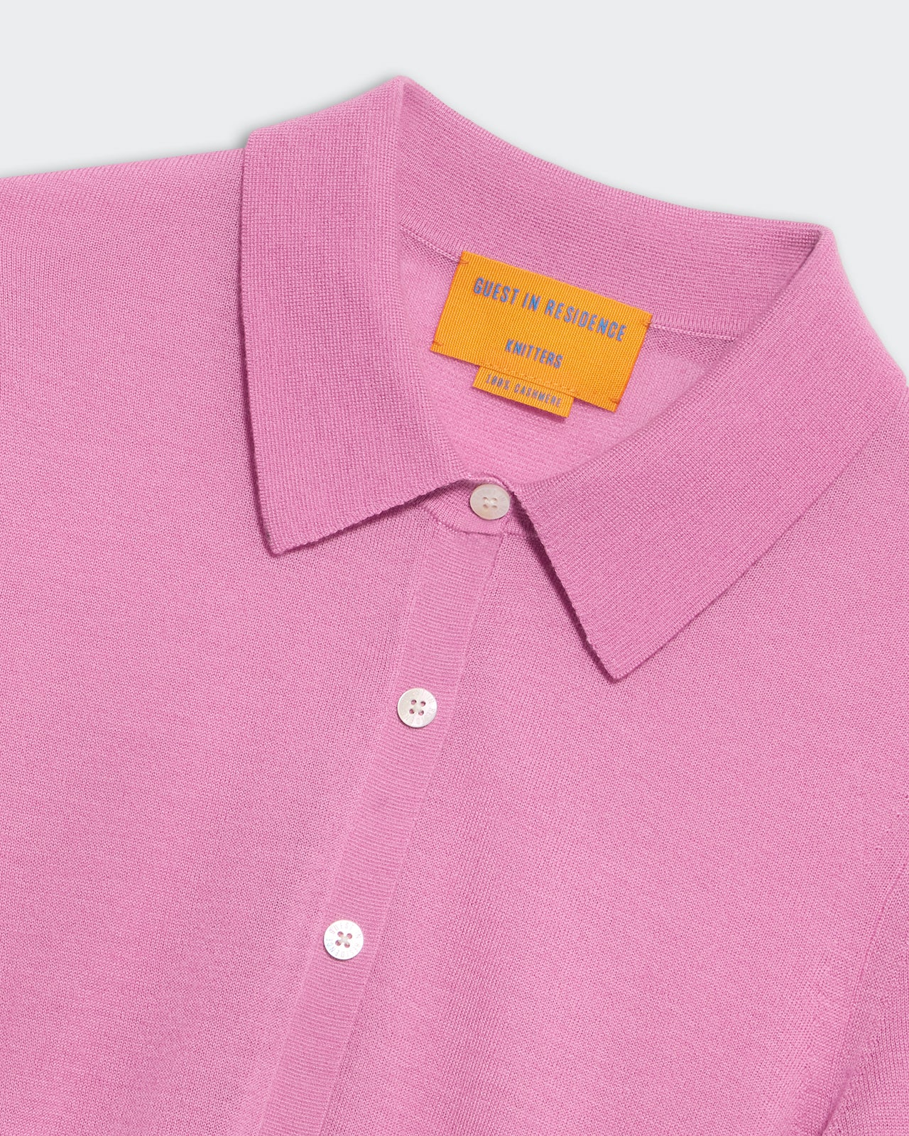 Close-up of rose pink cashmere button-down Elle shirt with collar and branded label inside neckline