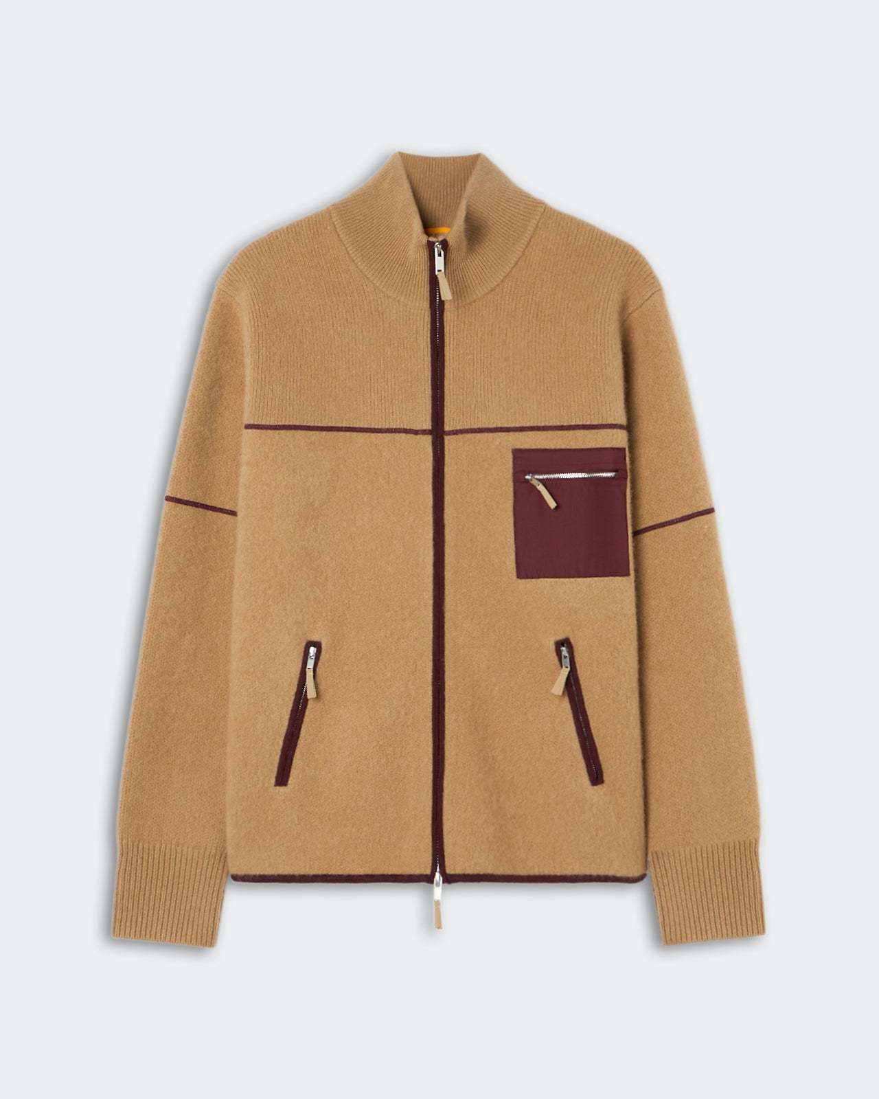 Beige zip-up jacket with dark brown trim, featuring a high collar, ribbed cuffs, two vertical zippered pockets at the front, and one small zippered chest pocket.