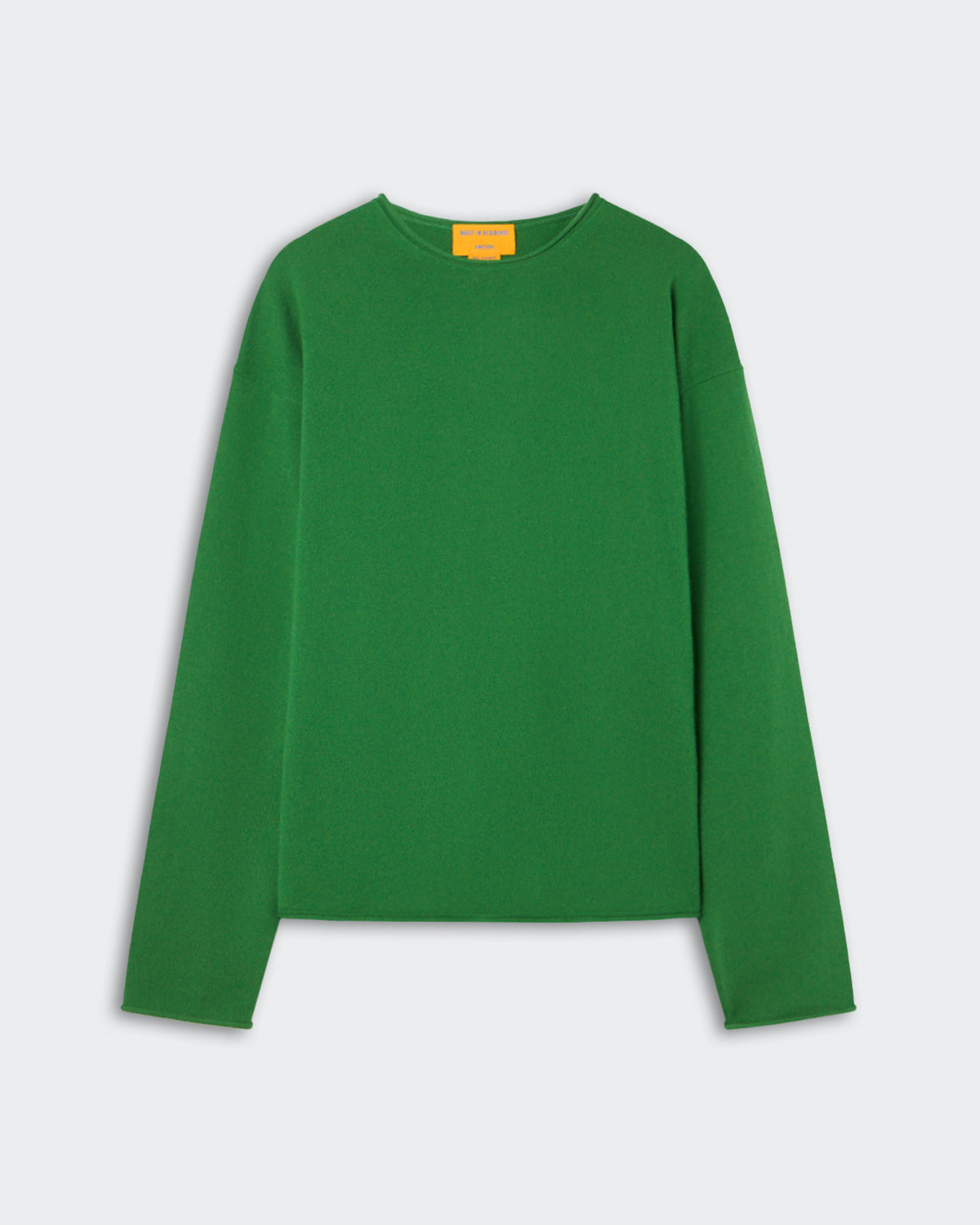 Green long-sleeve crew neck sweater laid flat on a light gray background with a small yellow tag visible inside the collar.