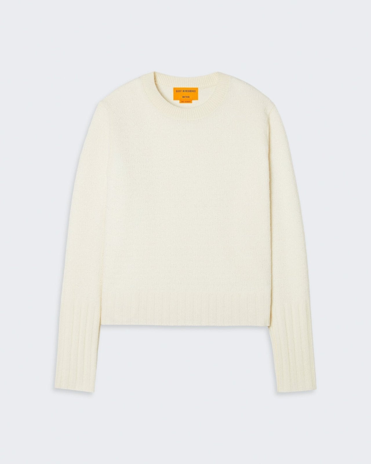 Cream-colored cashmere sweater with pointelle detail and ribbed cuffs and hem.