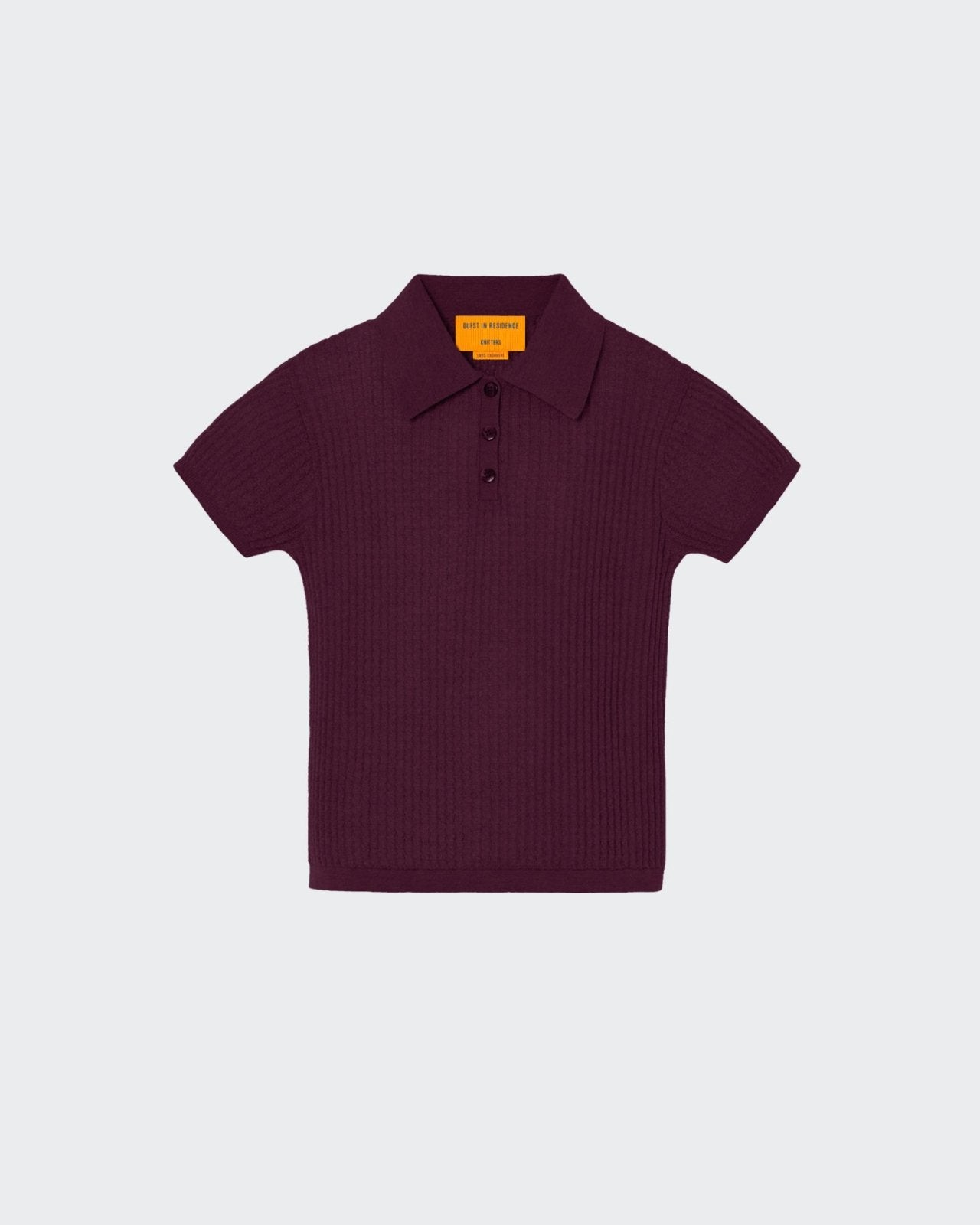 A burgundy-colored women's polo shirt with a textured waffle knit pattern, featuring a collared neckline and three-button front placket, with the signature GIR branding at the center back neck.