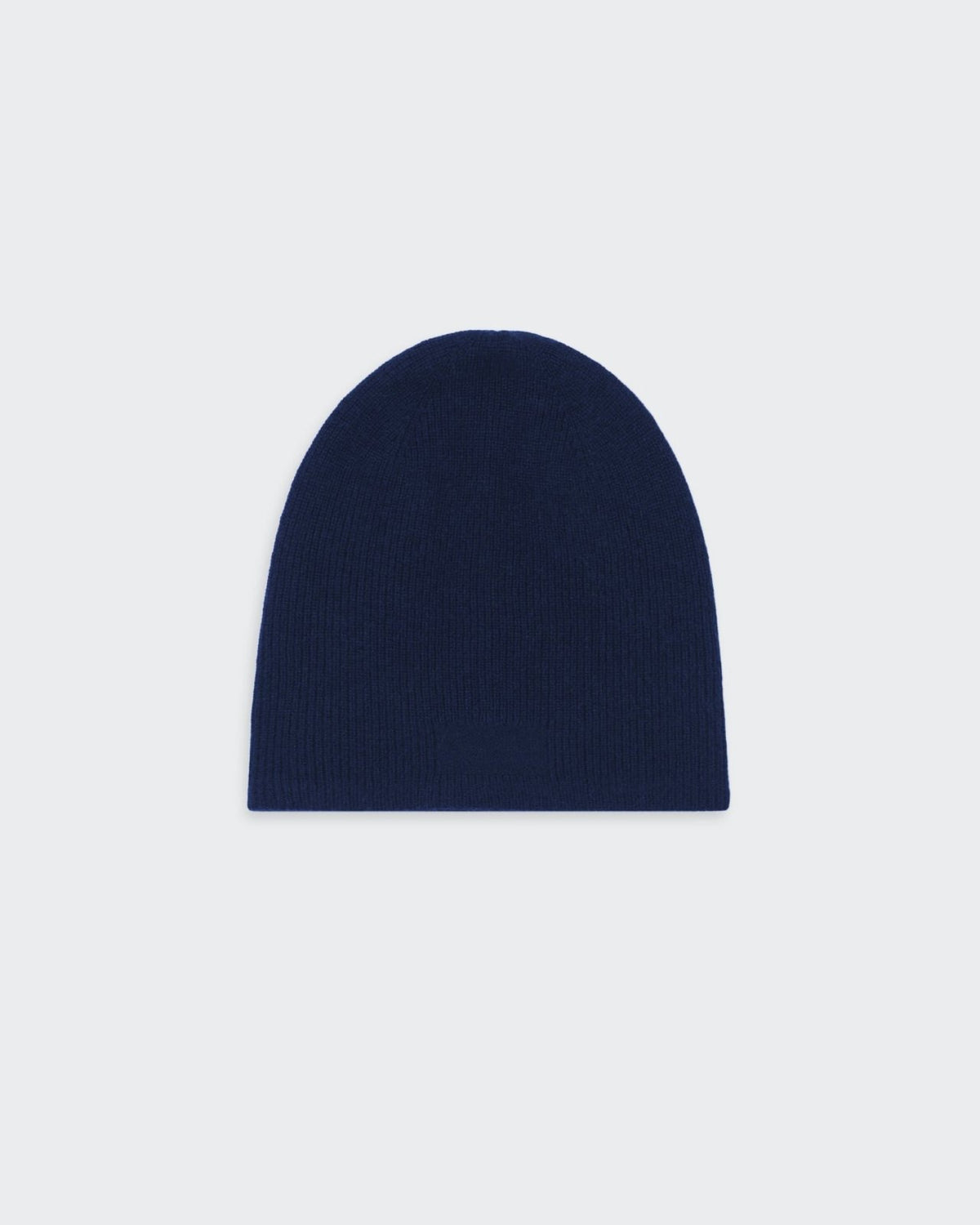 A navy blue, reversible, cashmere knit beanie hat with a simple, minimalist design.