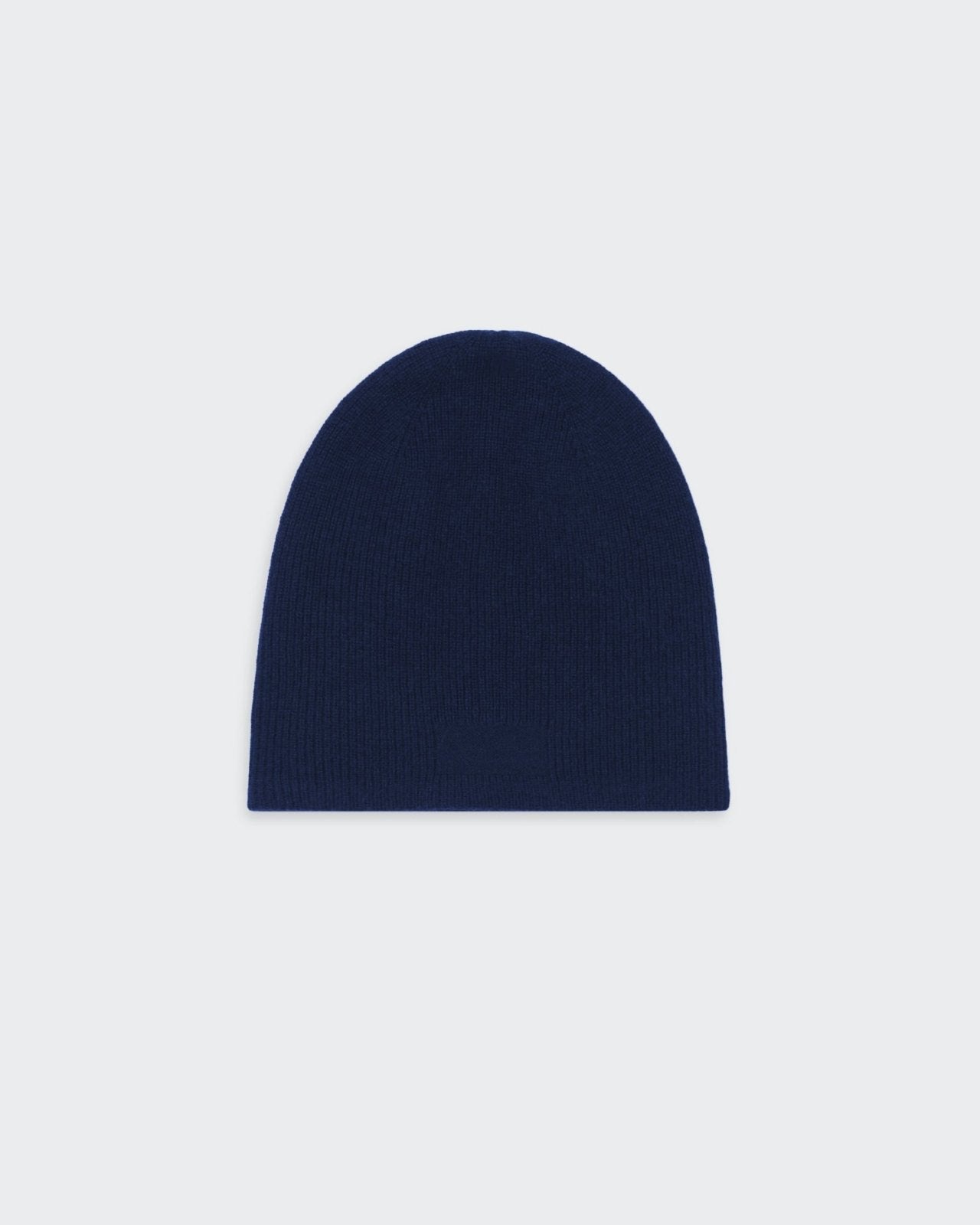 A navy blue, reversible, cashmere knit beanie hat with a simple, minimalist design.