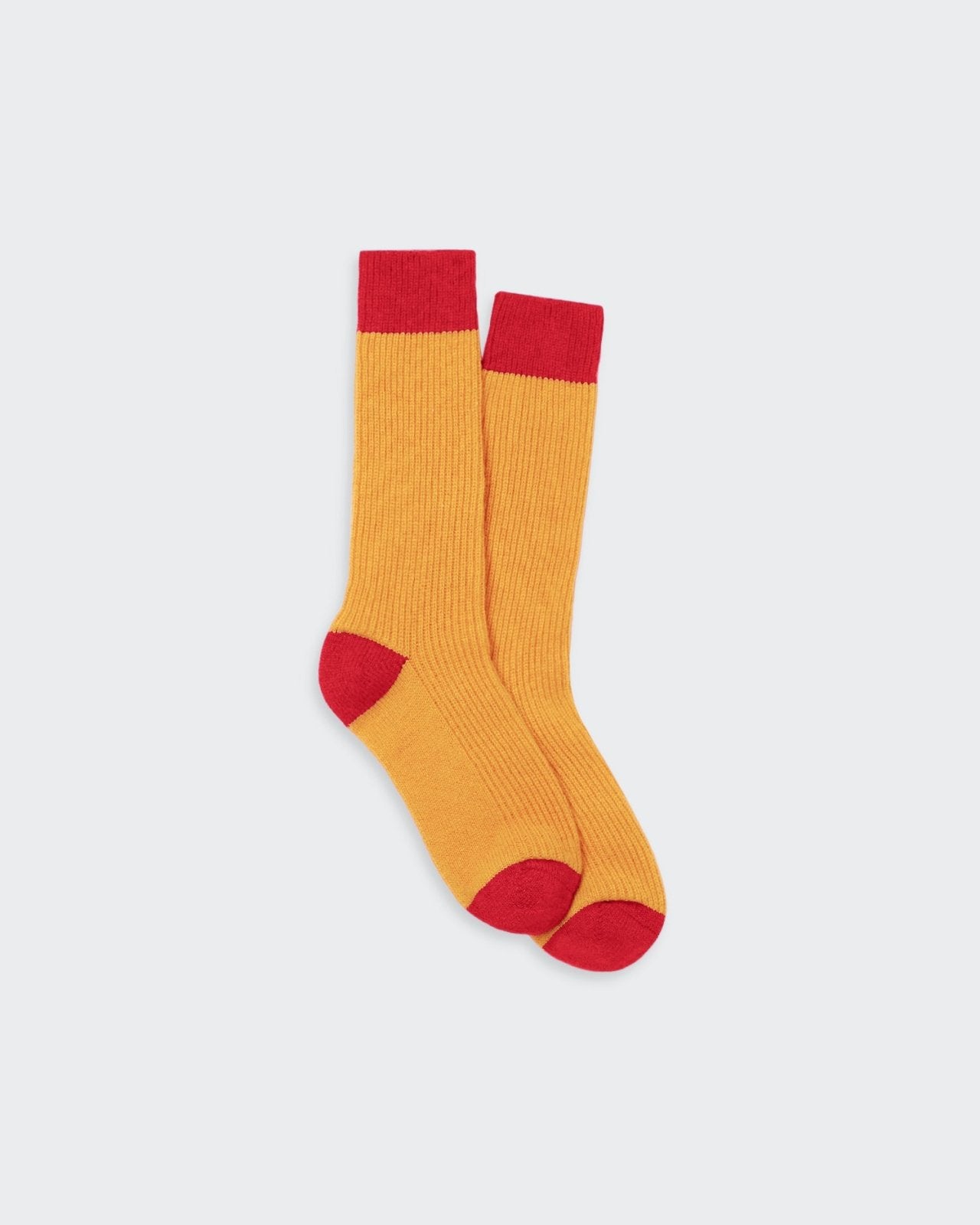 Colorful, cozy socks featuring a contrast color block design in warm tones of orange and red.