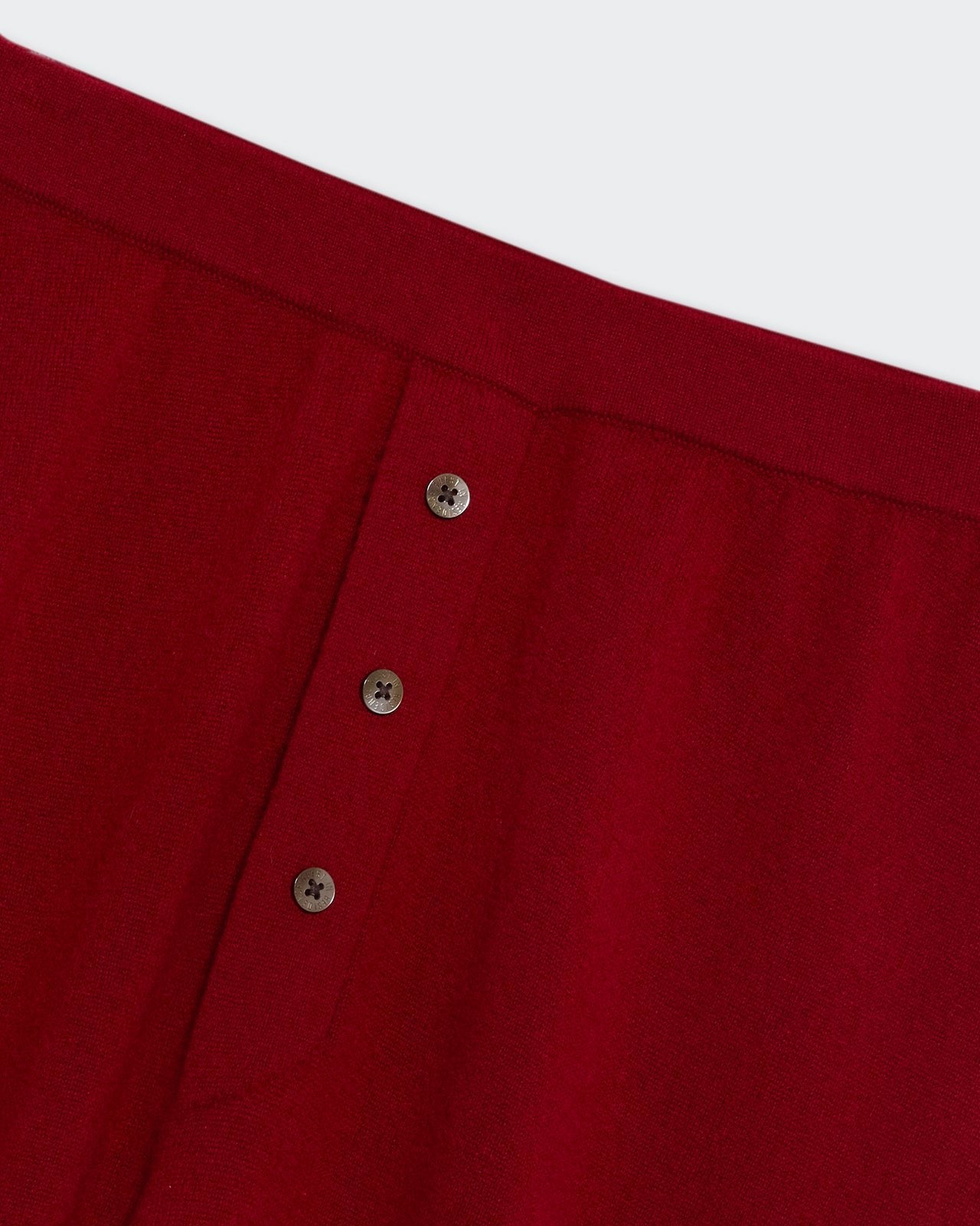 Everywear Pant - Ruby close-up of deep red fabric with three small brown buttons detailed on waistband