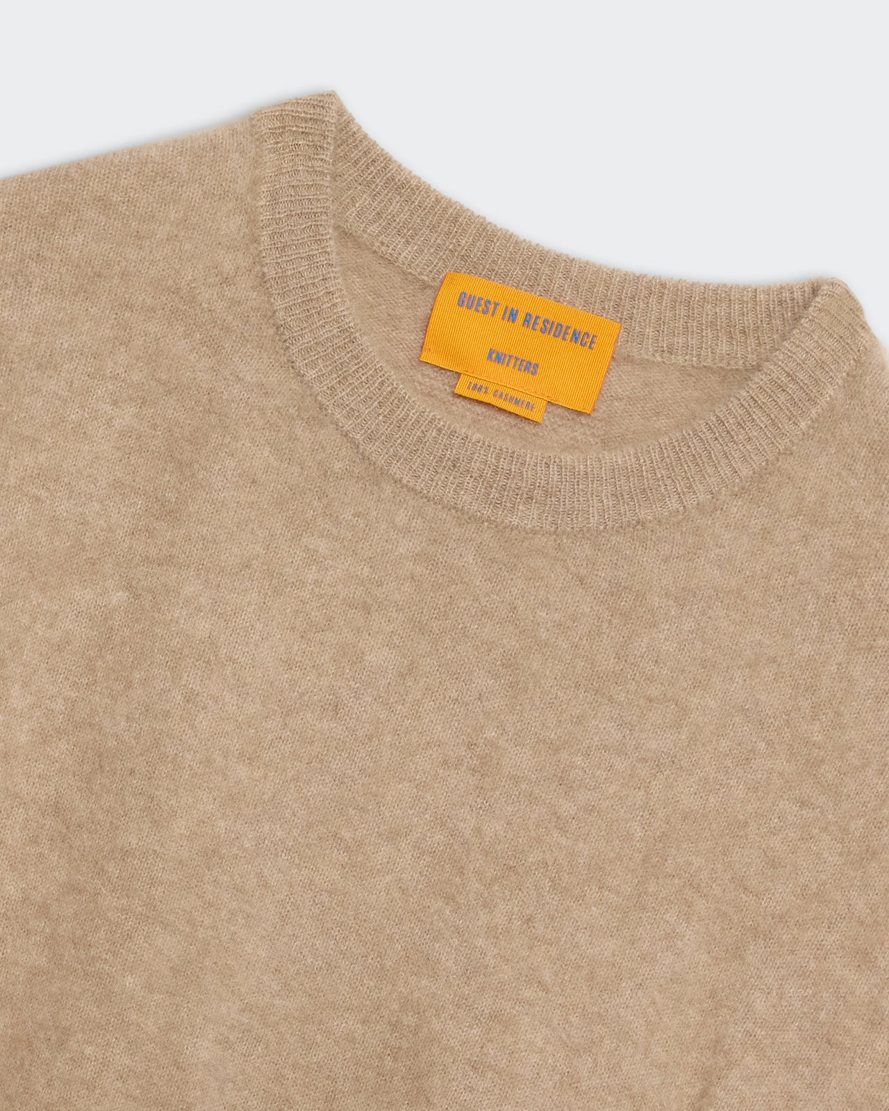 Grizzly Crew - Taupe soft knit crewneck sweater with ribbed collar and contrasting orange label detail.