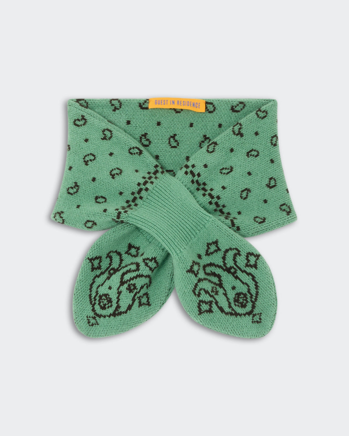 Bandana Bowtie Scarf - Highland/Burnt Cocoa in green with a knitted pattern and embroidered fish design, featuring a ribbed bowtie-style closure and a small orange label.